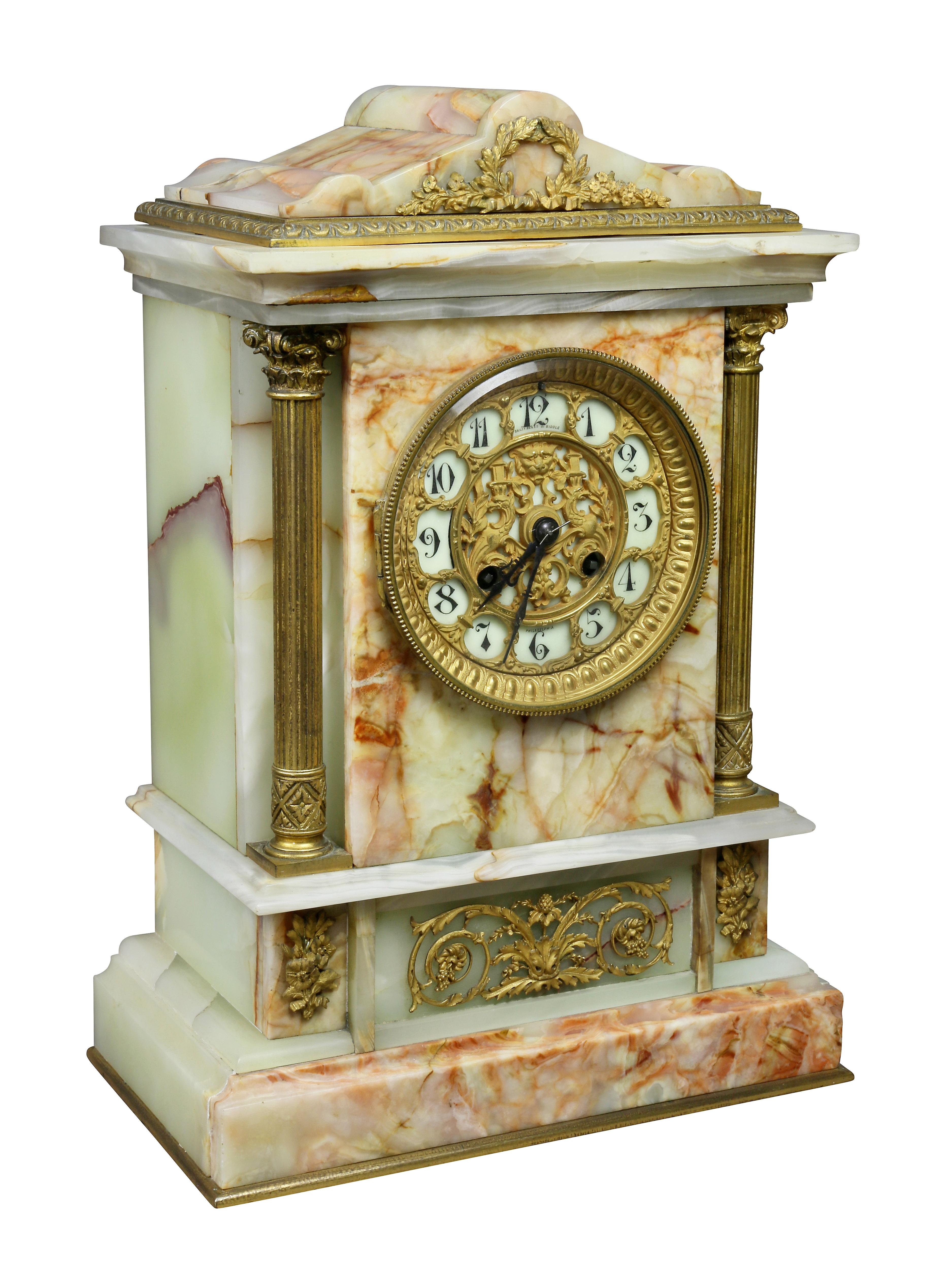 With arched pediment top with wreath mount over a clock face flanked by Corinthian columns. The base with rinceau central mount.