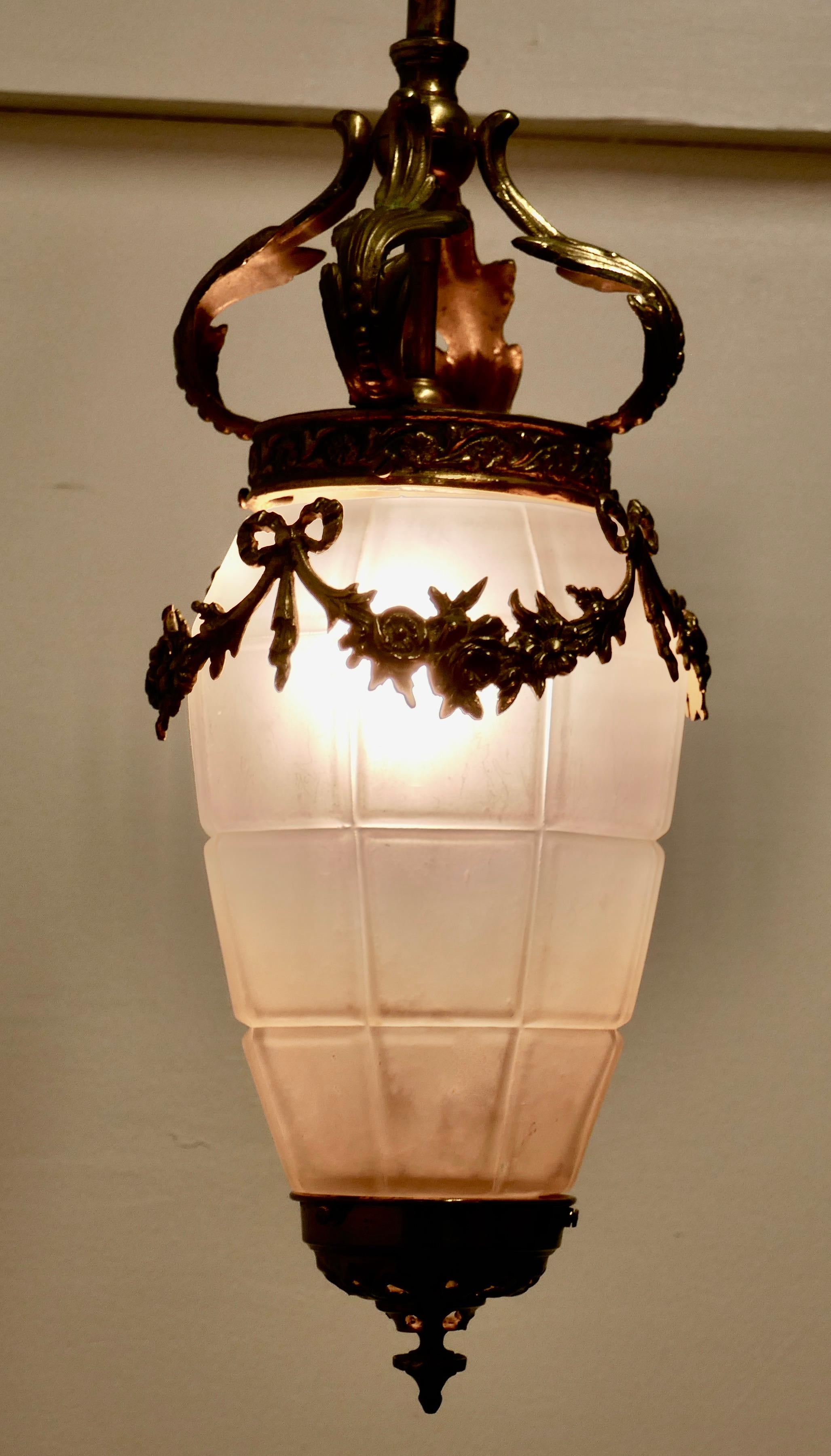 French opalescent glass and brass hanging pendant light

Charming and beautiful, this long pear drop opalescent glass shade is decorated with a bass Garland and hangs from an acanthus leaf crown on a long brass column 
A stunning piece in good