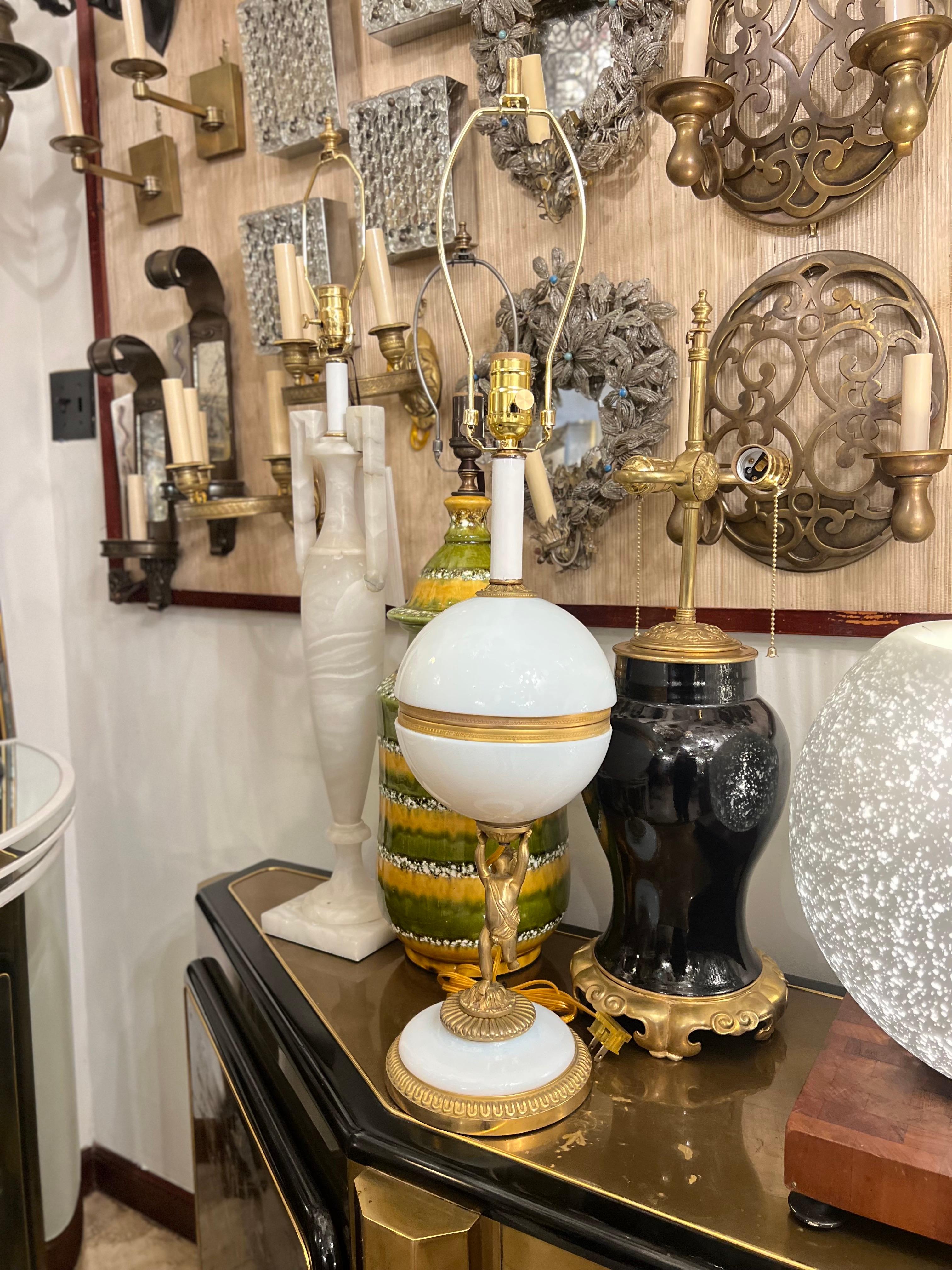 Lampe en verre opalin avec détails dorés, datant des années 1940.

Mesures :
Hauteur du corps : 20