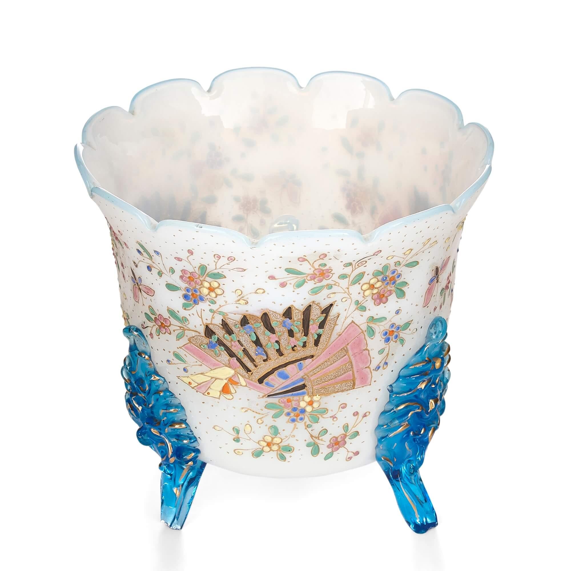 French opaline glass planter painted with floral designs
French, early 20th century
Measures: Height 14.5cm, diameter 15.5cm

This charming opaline glass planter features three bright blue glass legs and a body profusely painted with vibrantly