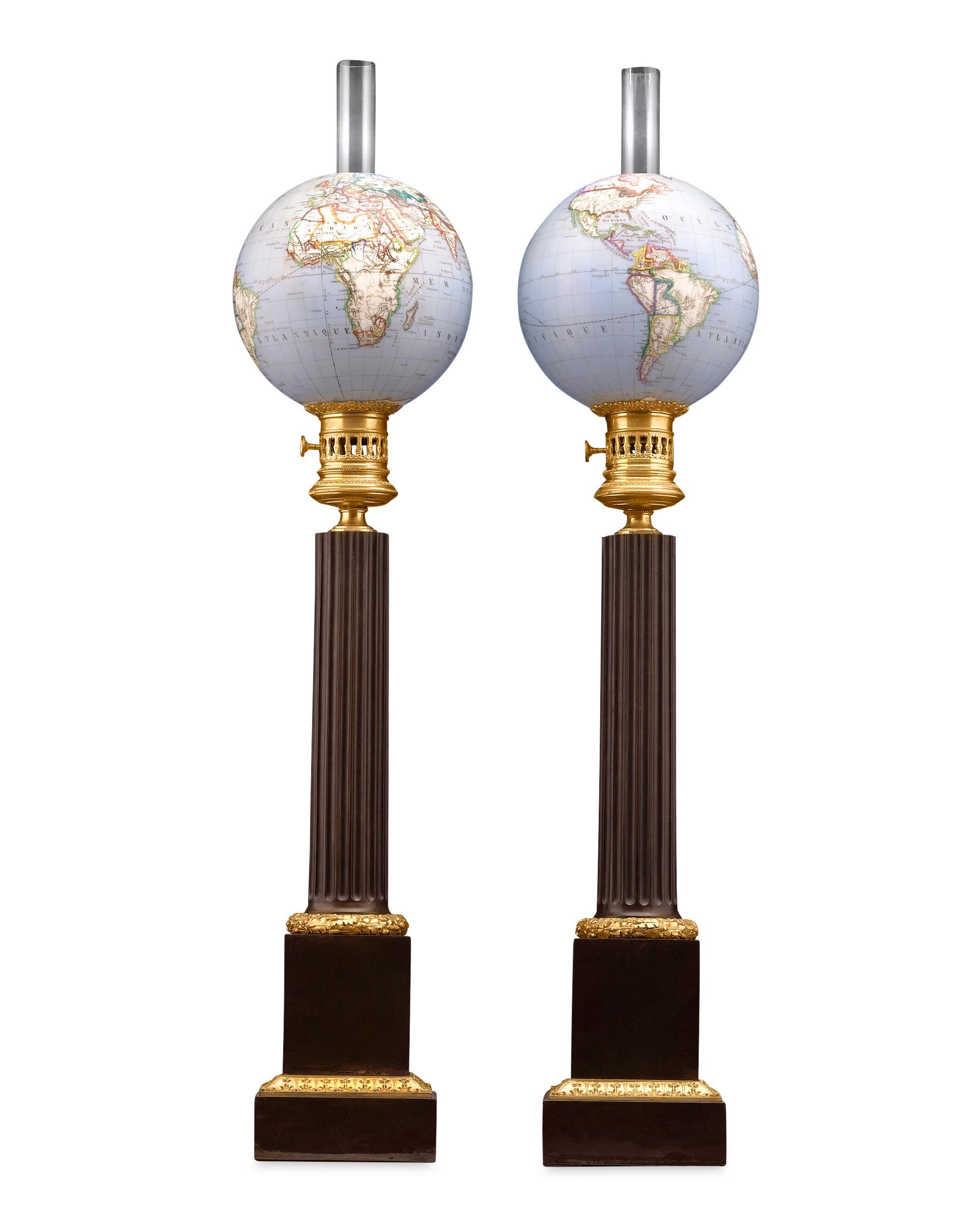 Astonishing translucent globes glow as lampshades in this rare and remarkable pair of French opaline oil lamps. The intricately crafted glass globes are simply radiant atop bases of beautifully crafted patinated and ormolu bronze in these Napoleon