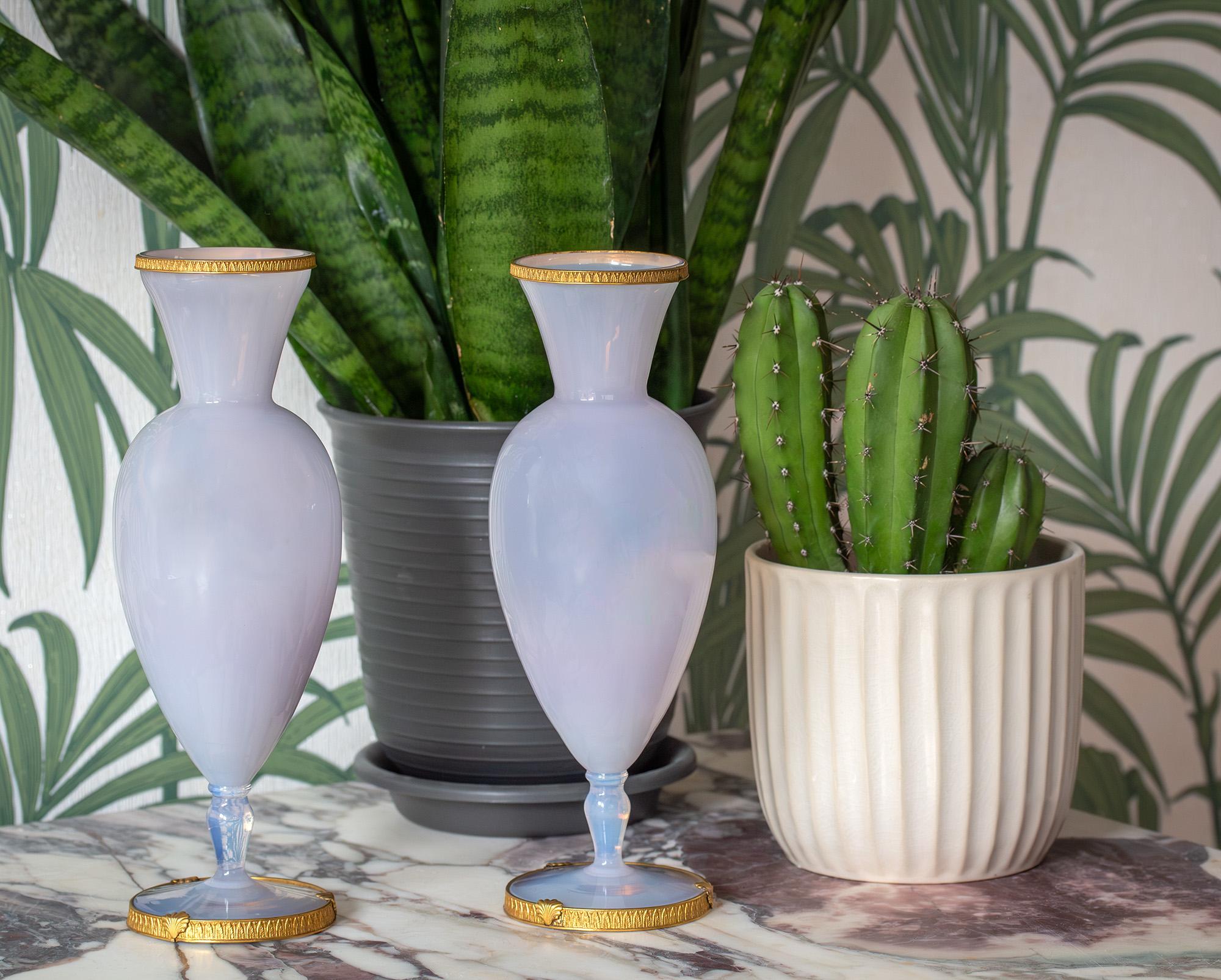 A beautiful pair of French ormolu mounted opaline vases. The vases with splayed feet upon pinched bases with globular bodies and tapered necks decorated with a light violet hue. The vases mounted with exceptional quality ormolu mounts to the top rim