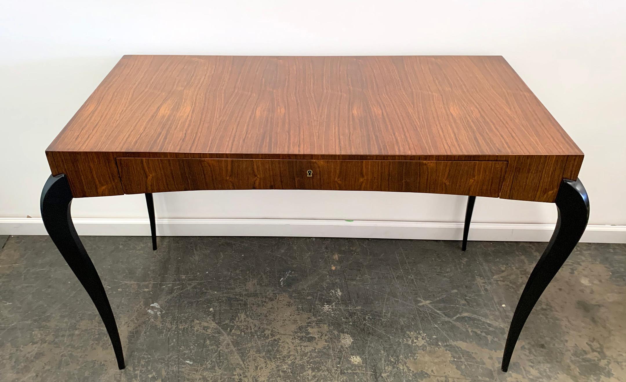 This desk is simply stunning. The rosewood grain is absolutely spectacular. This Art Deco desk from circa 1940 is clad in the most beautiful rosewood and has satin black ebonized legs.

The desk was indeed refinished at some point, and small