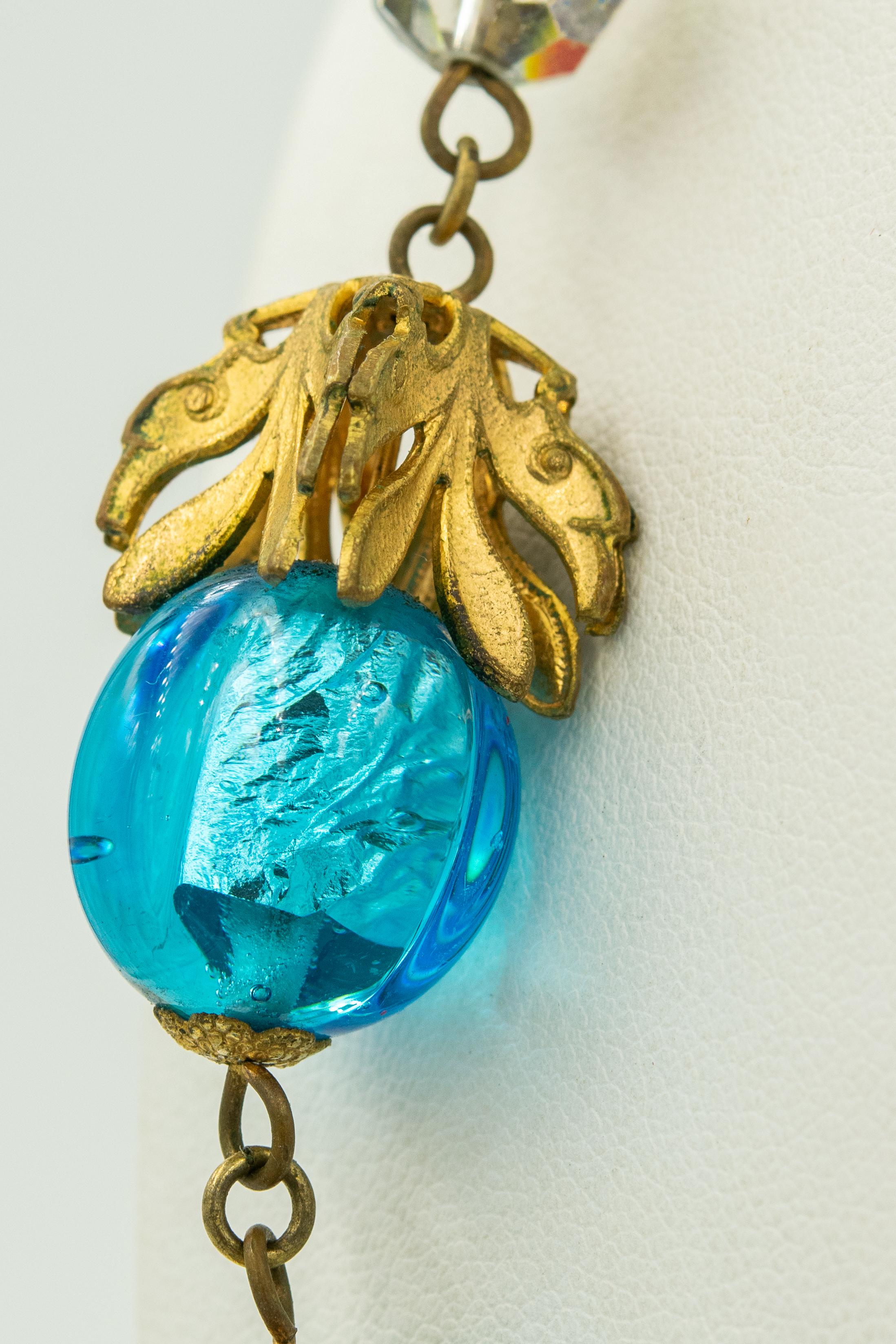 This necklace is gorgeous.  I love the foil within the blue glass bead gives the piece such dimension and life.  The draping gilt leafs makes you fee like you are in a secret garden or perhaps under water.  Accented among the larger beads are 5