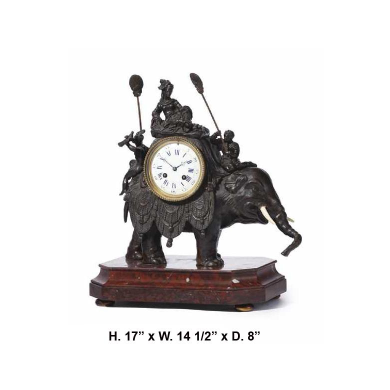 Spectacular French orientalist bronze patinated and rouge marble elephant clock, 19th century.
The clock is surmounted by a reclining aristocratic noble in traditional garments flanked by two additional orientalist figures wielding fans, over a