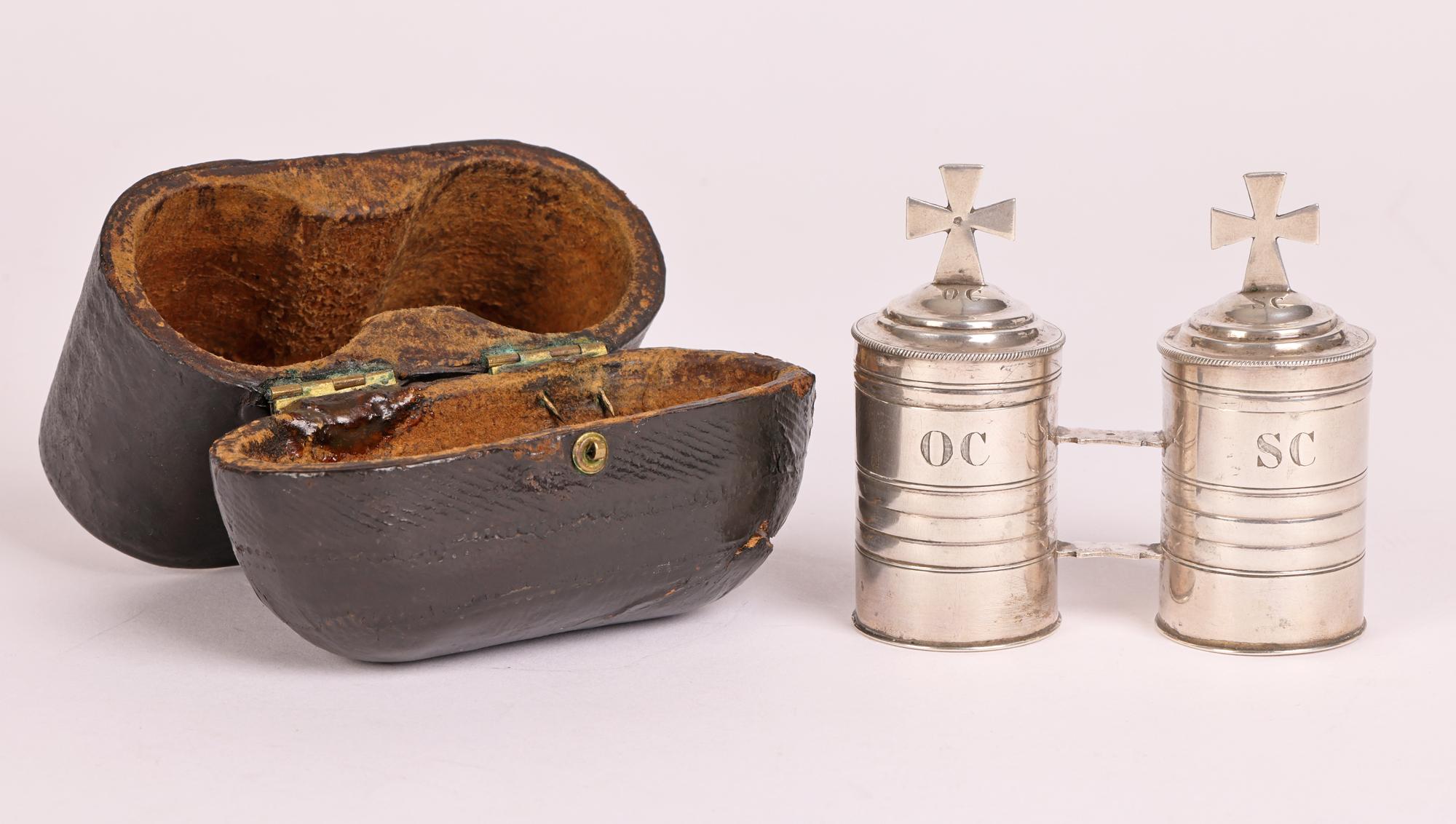 A very fine and scarce French pair silver Baptismal oil containers in its original leather fitted travelling case dating from 1850. The two cylindrical shaped oil containers are conjoined and both have tight fitting covers mounted with crosses. The