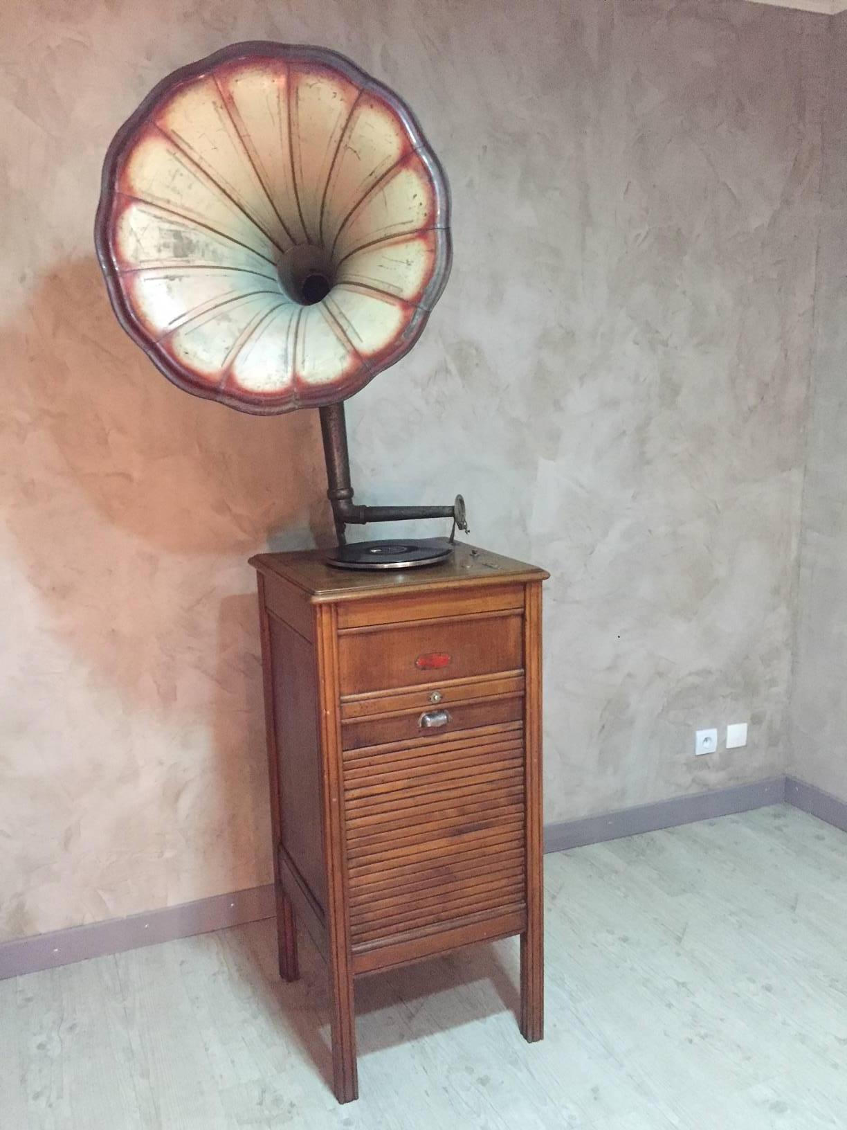 Rare French walnut working gramophone with a storage for disks. 
The needle hasn't been changed. The metal pavilion is in good condition and with original painting. It can be moved in the orientation you wish.
The storage part for disks is walnut