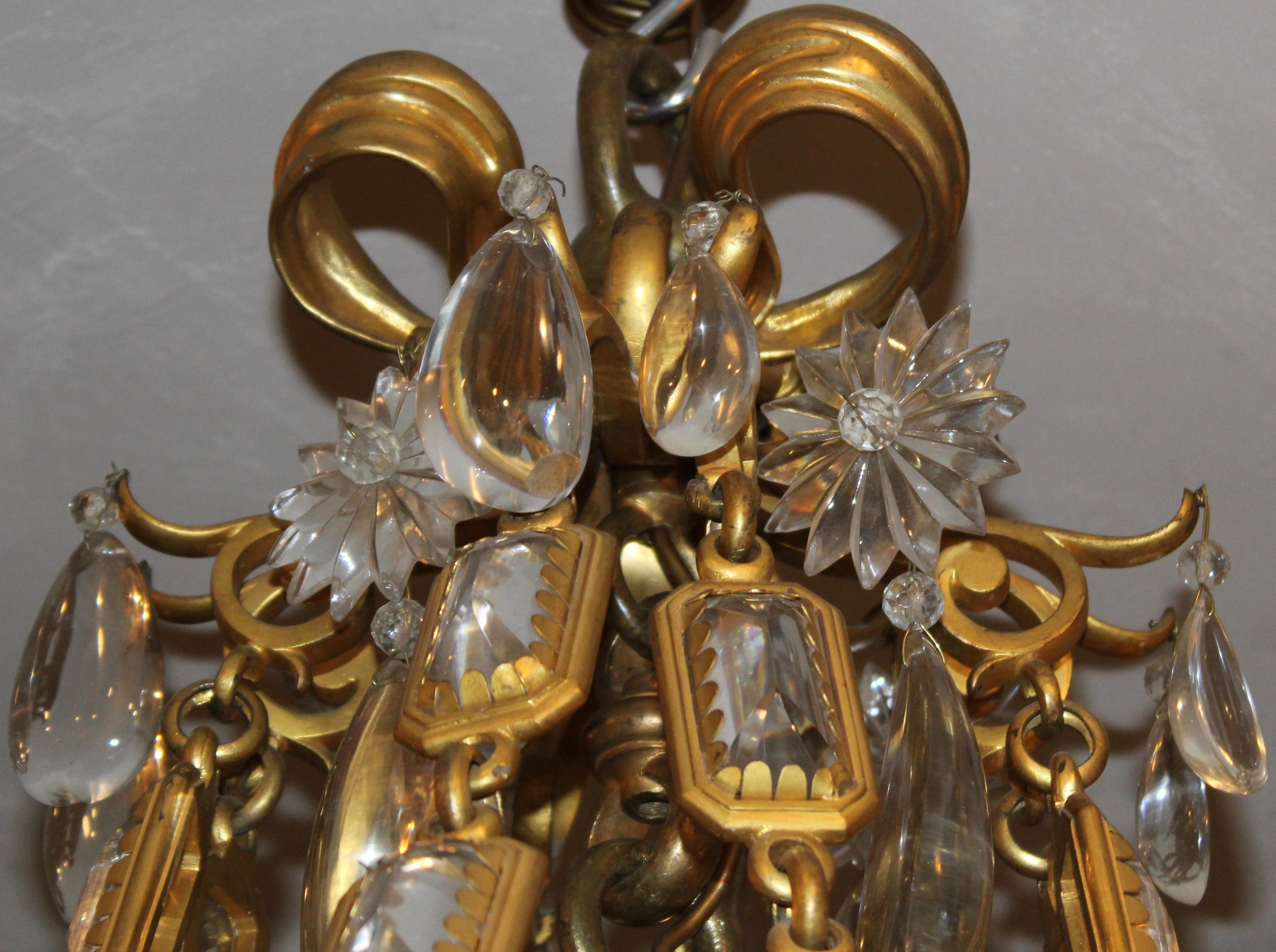 Impressive and substantial French Belle Époque ormolu chandelier c.1900. The very top of the chandelier with a cast ormolu bow finial, supporting eight bezel mounted faceted crystal chains. The four arms formed of elaborate scrolling motifs, that