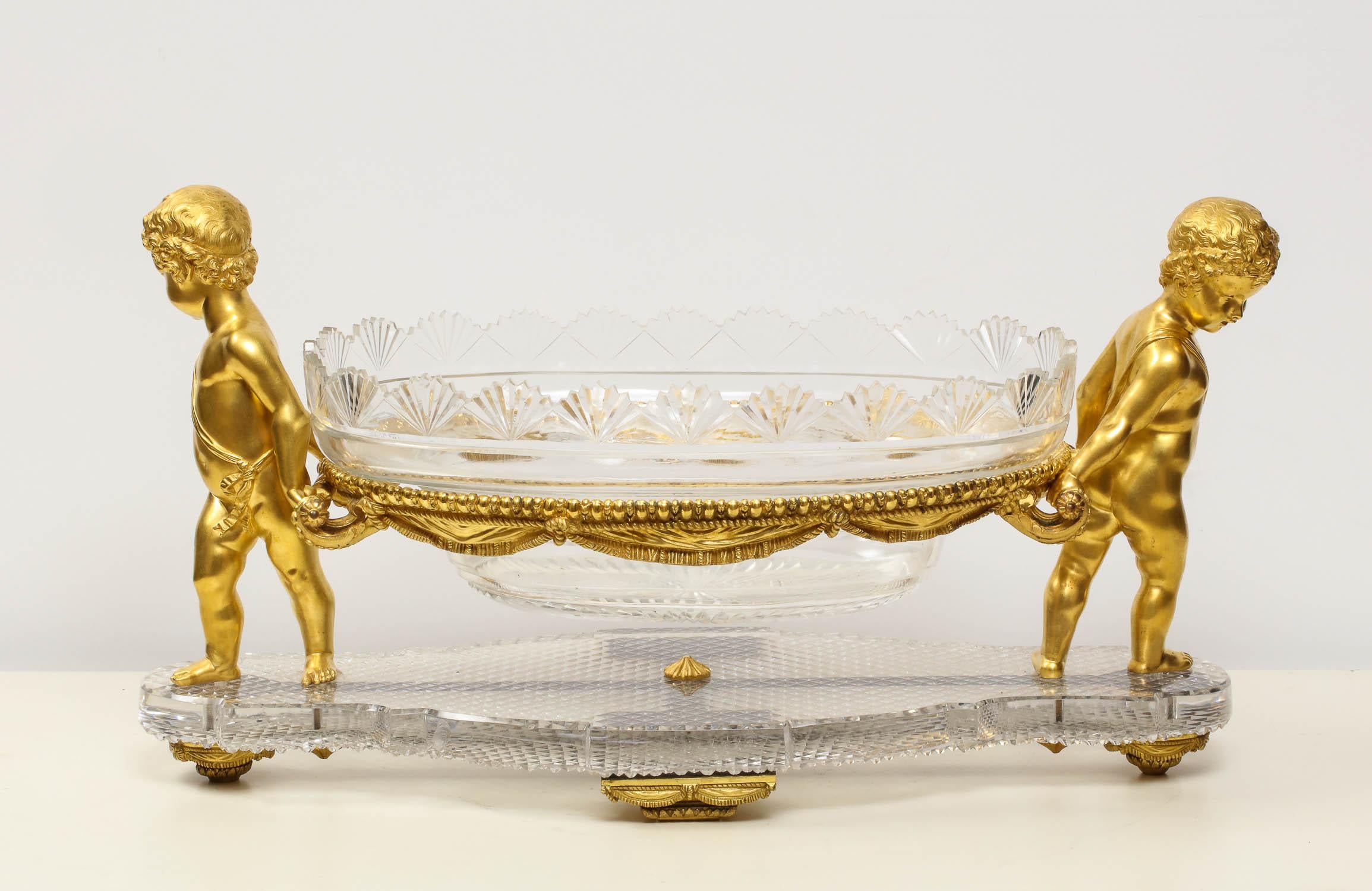 A French ormolu or bronze and cut-glass centerpiece by Baccarat Paris, circa 1870.

The center bowl supported on basket, flanked by two cherubs resting on ormolu supports, shaped cut-glass basket.

Very good condition. Ready to place.

Measures: