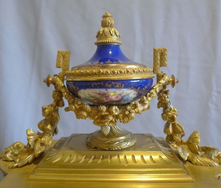 French ormolu and blue porcelain mantel clock. The blue porcelain with blue ground and decorated with swags of flowers and having jewelling. The fine original ormolu with silver highlights to some leaves and buds, a feature found only on the finest