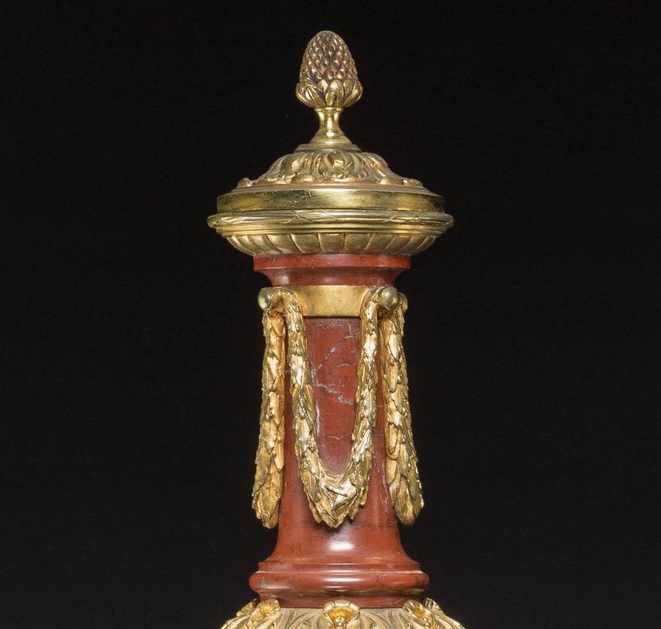 Our pair of vases with covers by Gagneau of Paris, originally fitted as oil lamps, are modelled as neoclassical maidens supporting vases. Crafted from rouge marble with ormolu bronze mounts. Removeable lids reveal the removeable pierced fittings