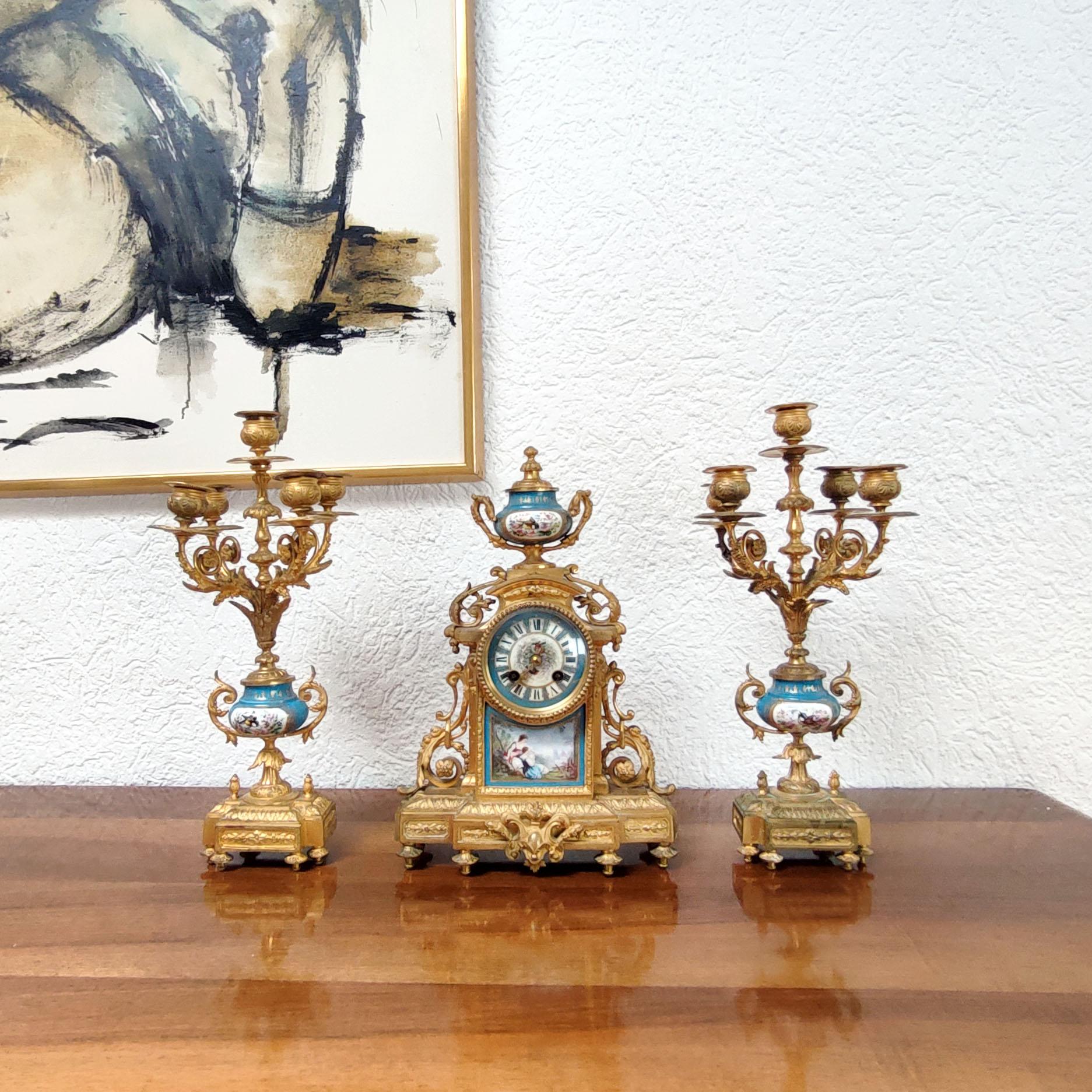 Antique French Louis XVI ormolu and porcelain mantle clock and pair of candelabra, late 19th century.
Gilt bronze and porcelain chimney accessories in the style of Sevres.
The pendulum clock is ornate with a porcelain plaque with décor of young