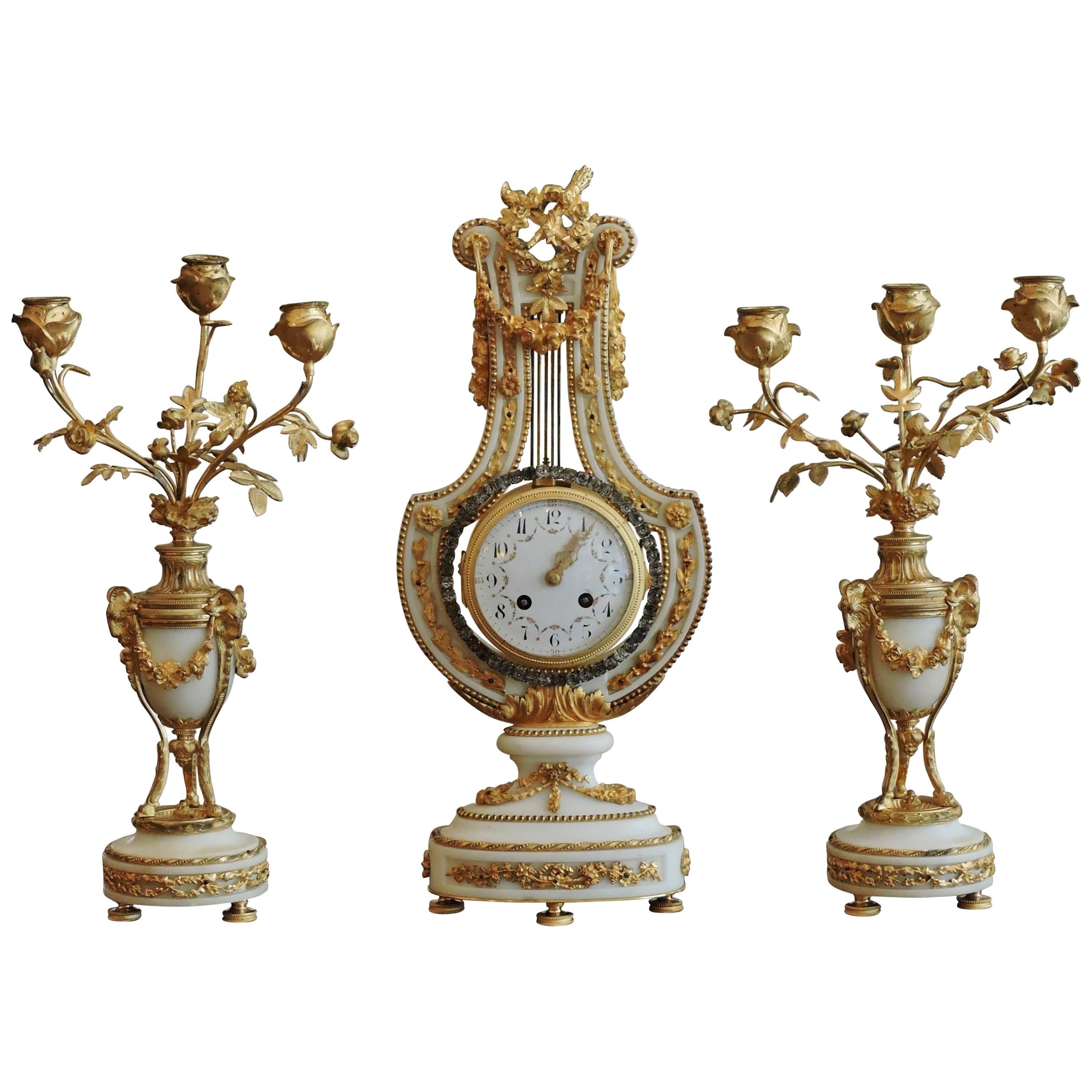 French Ormolu and White Marble Three-Piece Lyre Shaped Clock Garniture