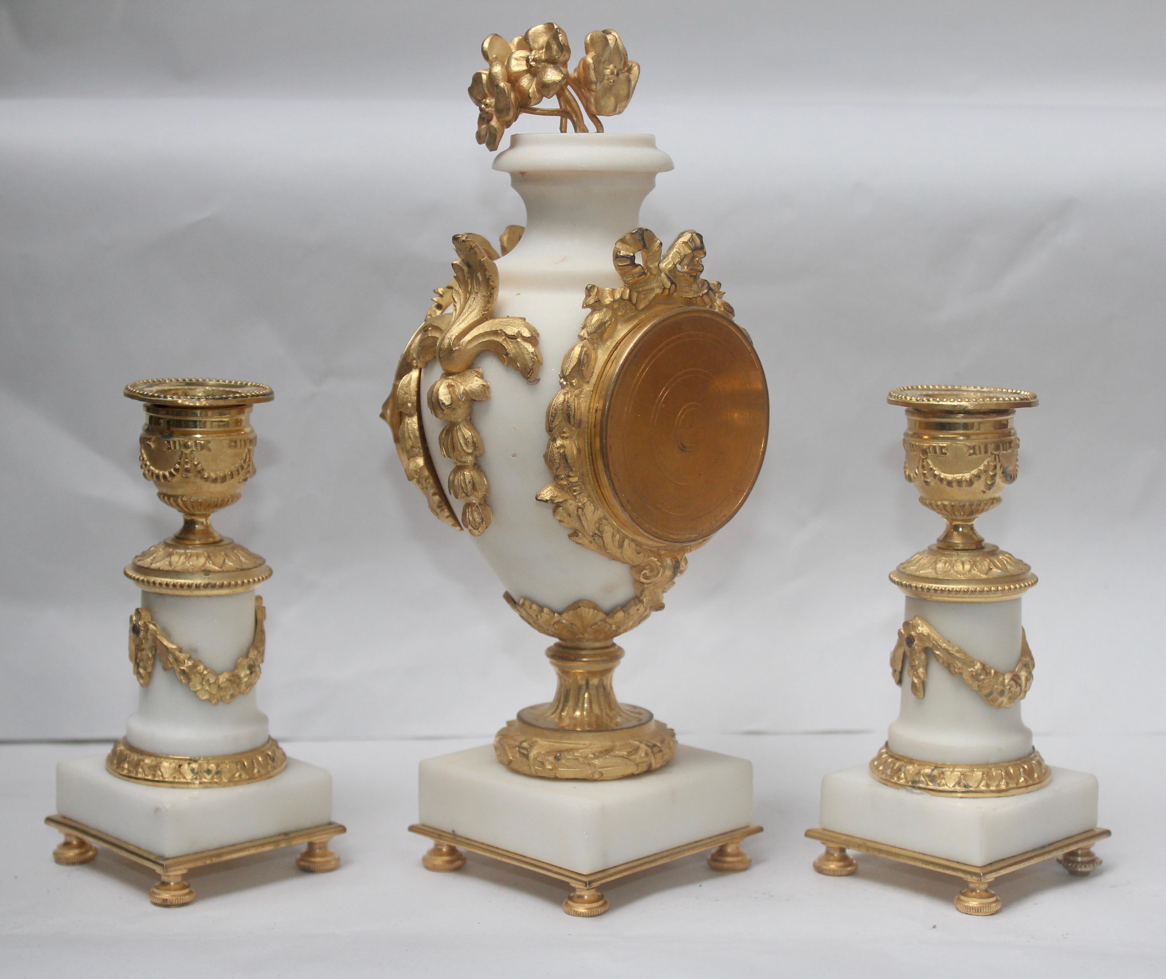 Gilt French Ormolu and White Marble Three-Pieces Vase Shaped Clock Garniture