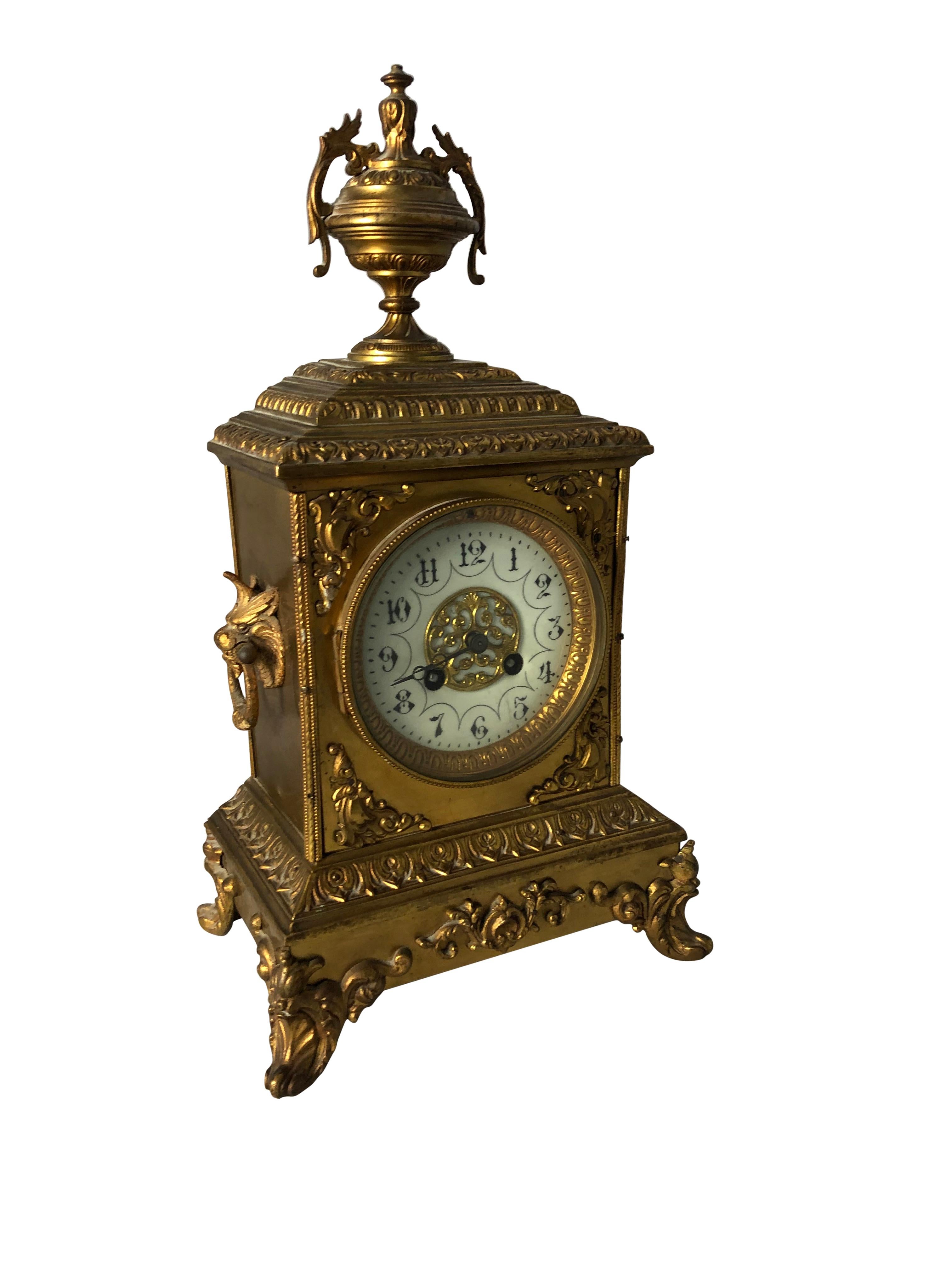 A fine quality French Ormolu mantel clock, 19th century, in Sevres Manner. The ornate case with finely cast detailed mouldings and cornice, surmounted by a floral decorated urn, the front set with porcelain plaque, raised on floral feet, the dial