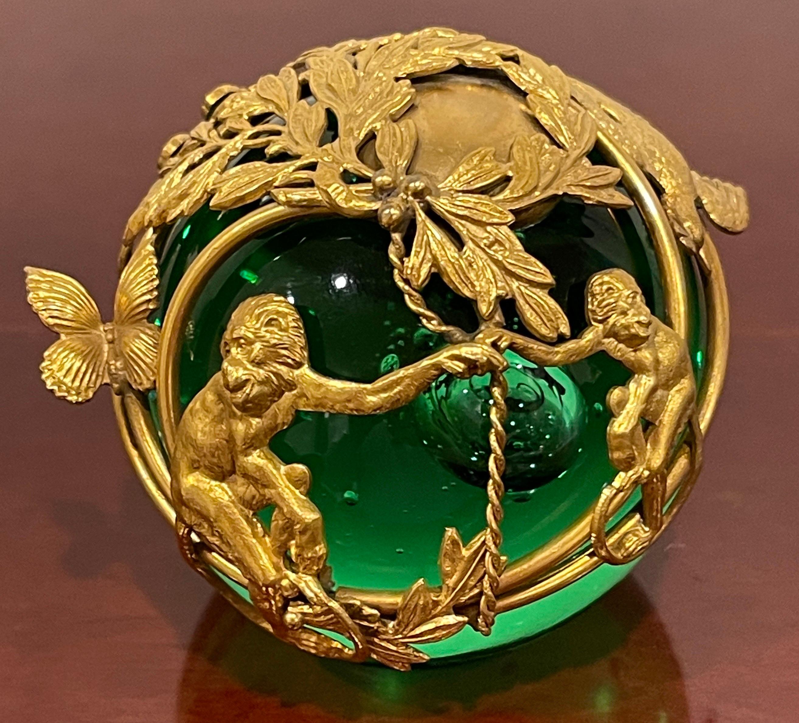 French Ormolu monkey motif green crystal controlled bubble paperweight.
France, Circa 1900s.
An extraordinary work, with fine cast ormolu mounts with continuous frame depicting monkeys, birds, butterflies and an alligator in a landscape of