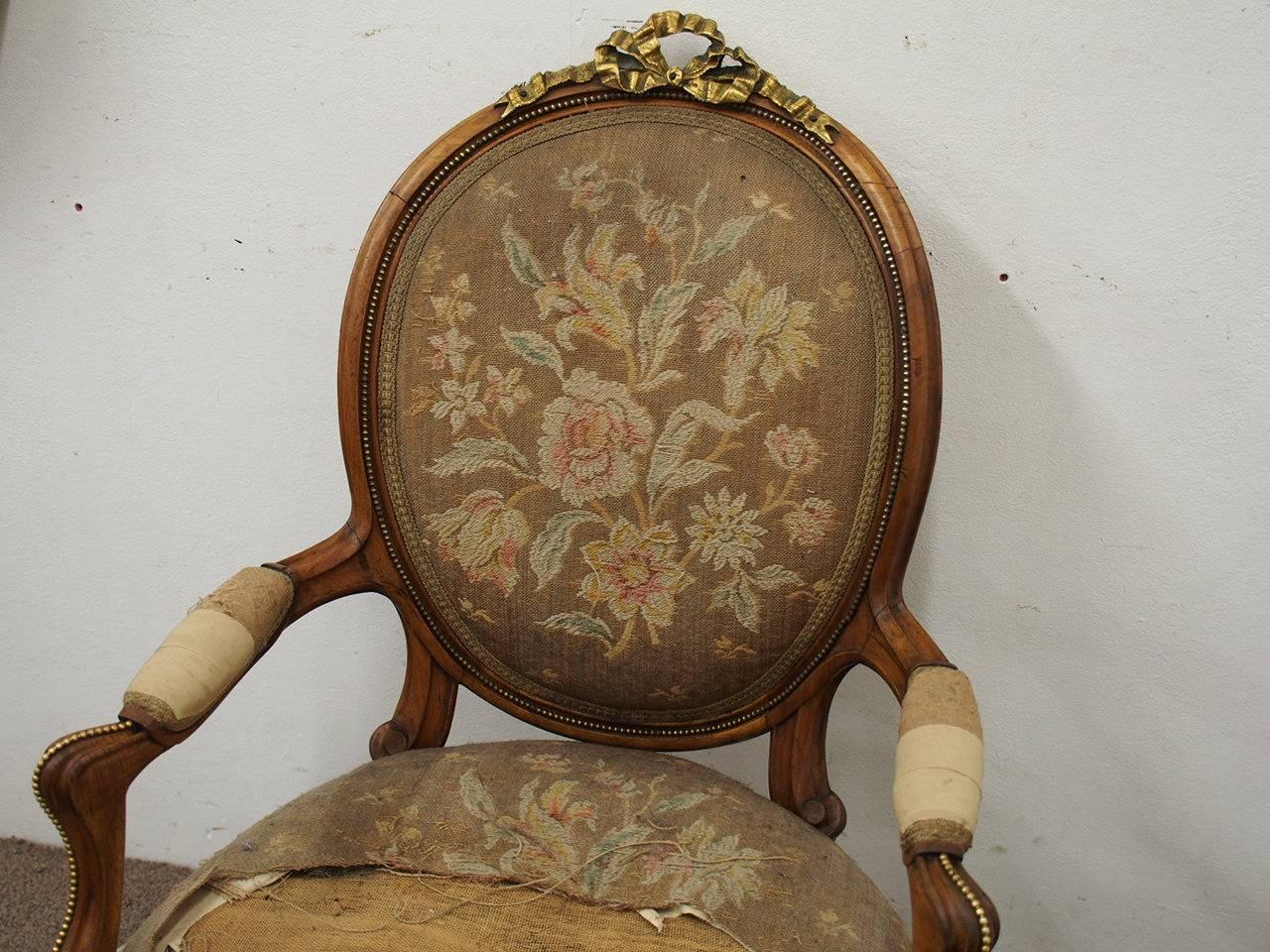 Exhibition quality French ormolu mounted walnut armchair (fauteuil), circa 1860. With a label of “Jeansleme Pere et Fils” (worked 1853-1861). The fluted oval back with beaded ormolu decorations is surmounted by an elaborate ormolu ribbon bow. It has