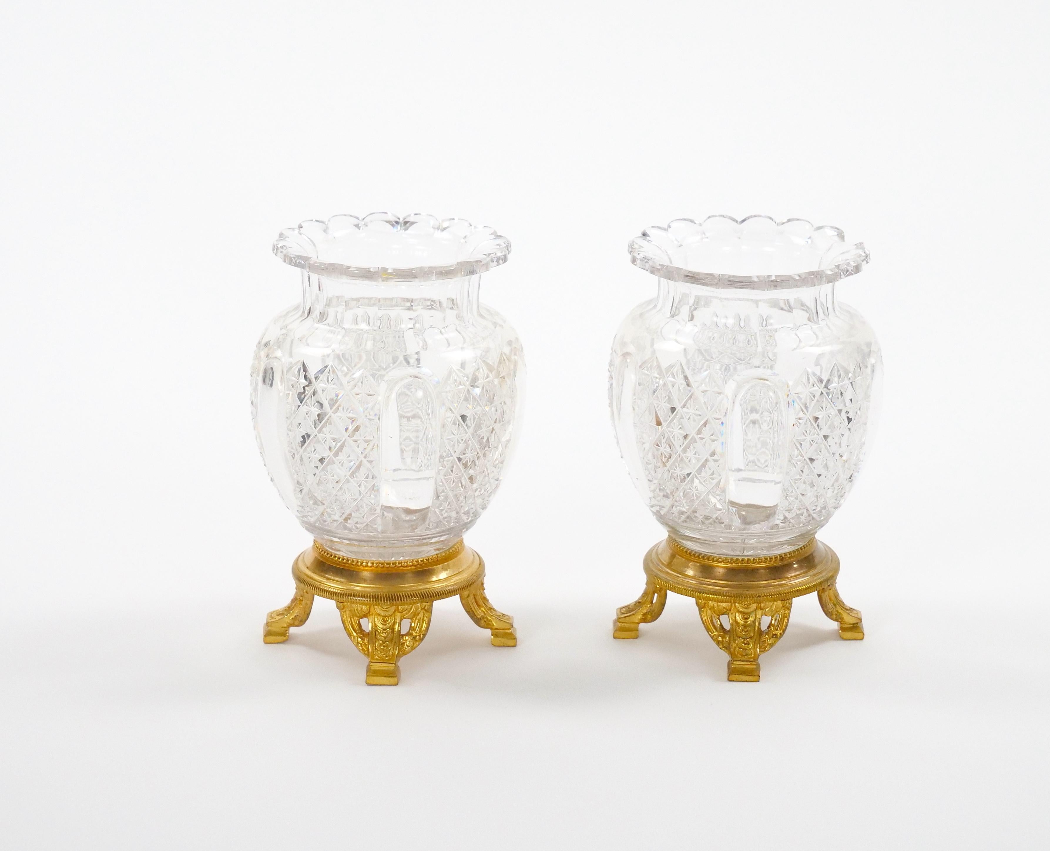 A charming example of refined French decorative art, this petite cut crystal vase with gilt bronze mounts beautifully captures the elegance of 19th-century craftsmanship.
The vase features exquisitely paneled and diamond-cut crystal detailing,