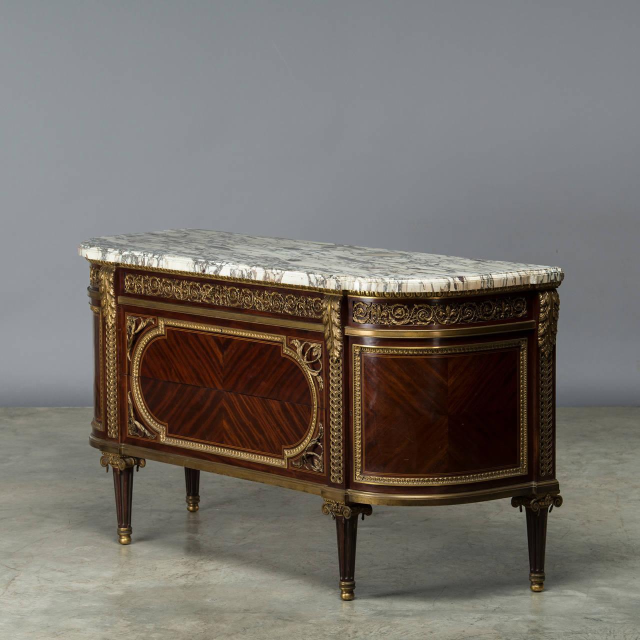 The breakfront demilune bréche Violette marble top above an egg-and-dart edge and scrolled foliage mounted frieze drawer.
Below, two long drawers with acanthus handles veneered sans traverse with boxwood stringing, flanked to each side by a