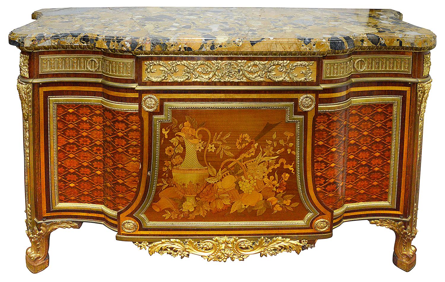 A French ormolu mounted mahogany and sycamore marquetry and parquetry inlaid commode.
After a model by Jean-Henri Riesener.
The shaped yellow and black-veined marble top above a breakfront frieze with three drawers over two cupboard doors