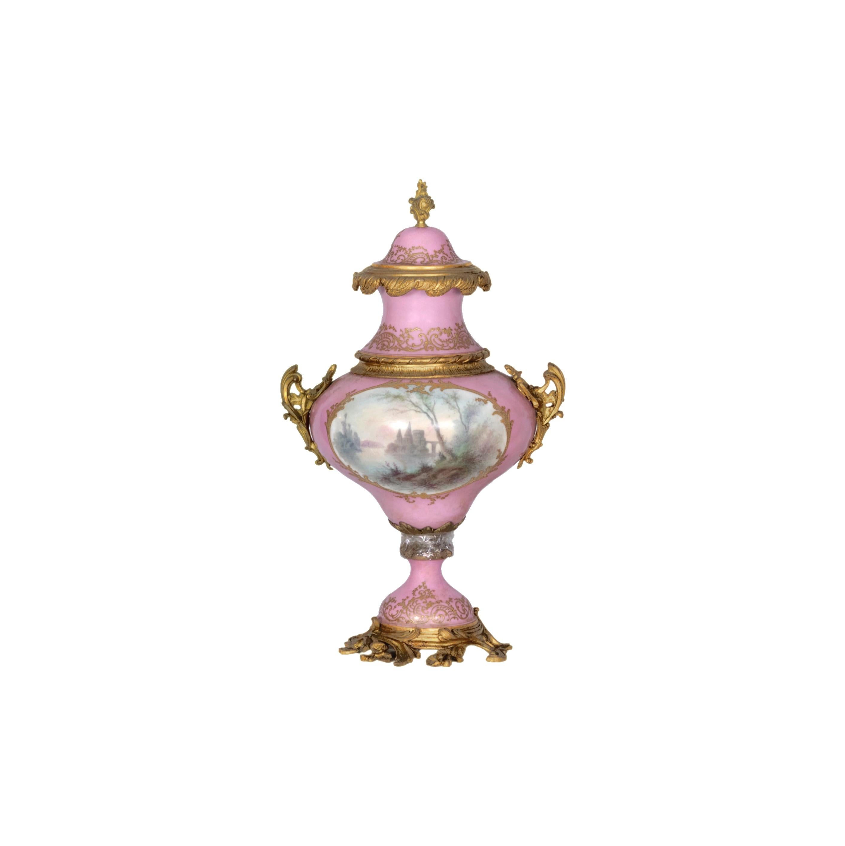 Belle urne décorative ancienne en porcelaine rose de Sèvres avec un fond peint à la main d'un musicien à la guitare et de sa dame. Une scène de sérénade.  Au fond, une scène de lac avec un château. 'E . Signature 