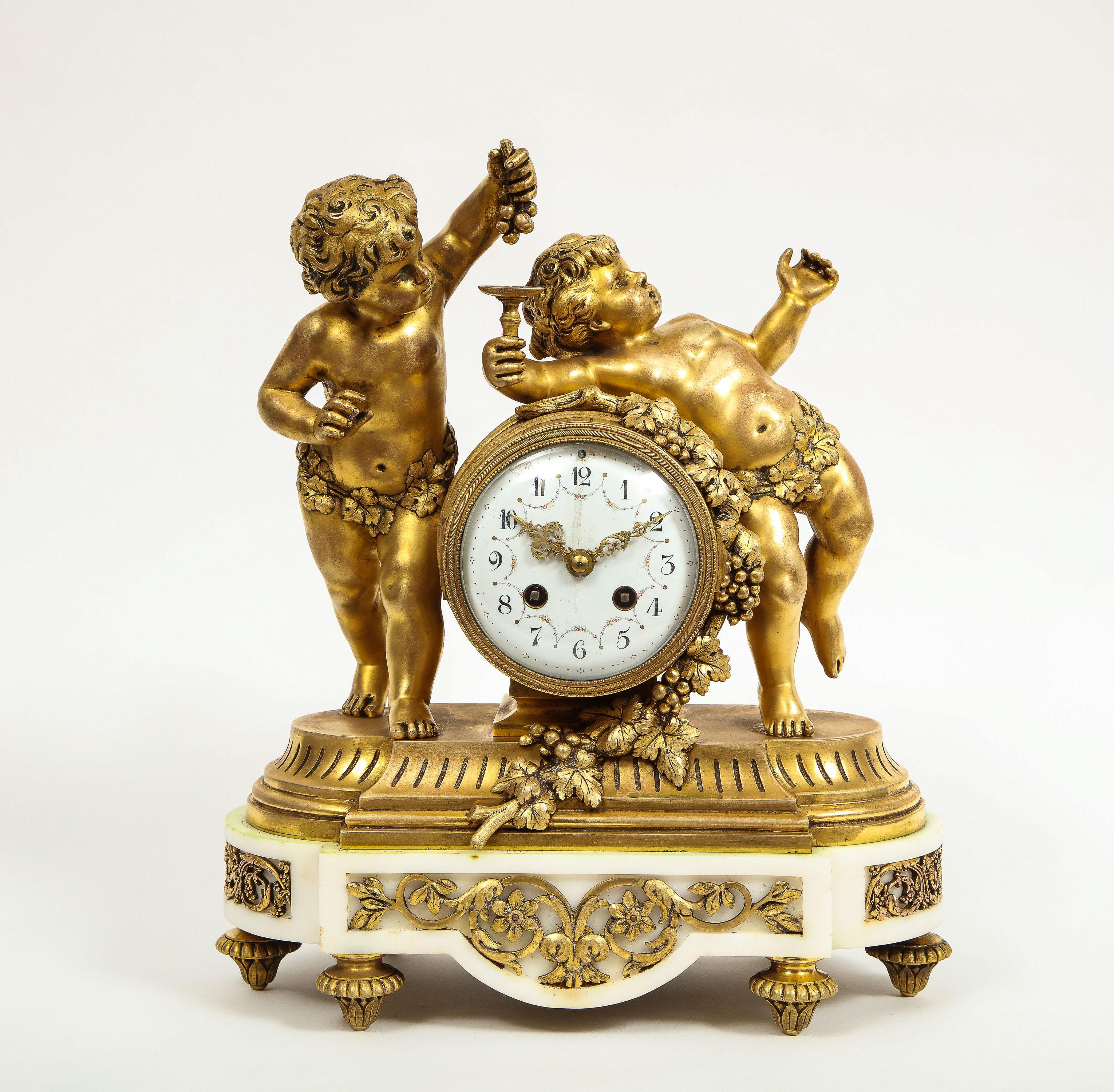French Ormolu-mounted white marble three piece clock garniture, after Clodion, circa 1880.

Comprising of a wine barrel shaped clock with two putti making wine from grapes, and a pair of two-light candlesticks depicting putti, signed