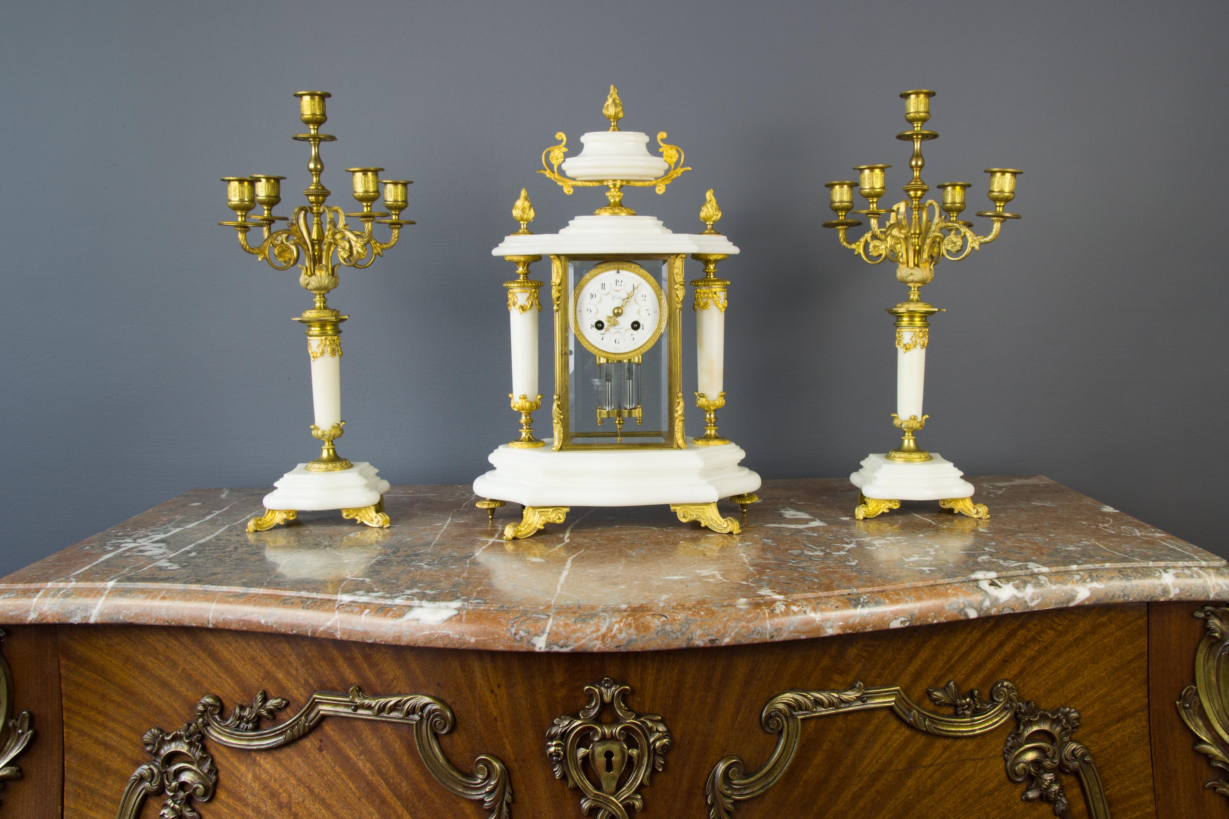 An antique 19th century French beautiful and well running white marble and gilt bronze mantel clock garniture set by A.D.Mougin. The marble is wonderfully sculptured in lovely curved detail.
Floral decorated porcelain dial with Limoges name on it, a