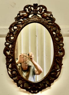 French Ornate Carved Oval Mirror, Decorated with Cherubs