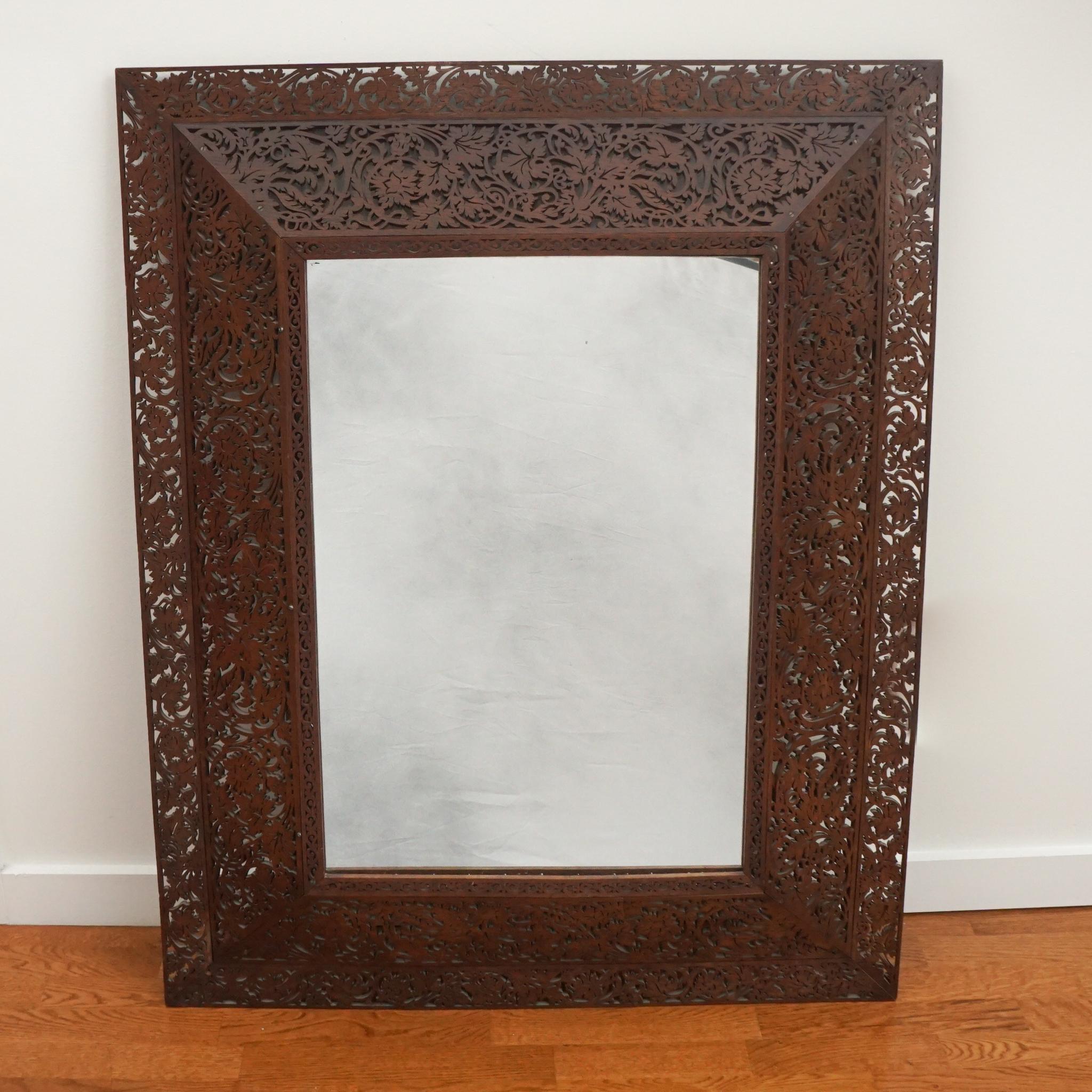 The exquisite carved wood frame mirror, shown here, is from France, c. 1890. Featuring an intricate carved wood frame, the mirror foliage scrollwork is exquisite.  Frame is built in four different sections, installed around the mirror. To hang this