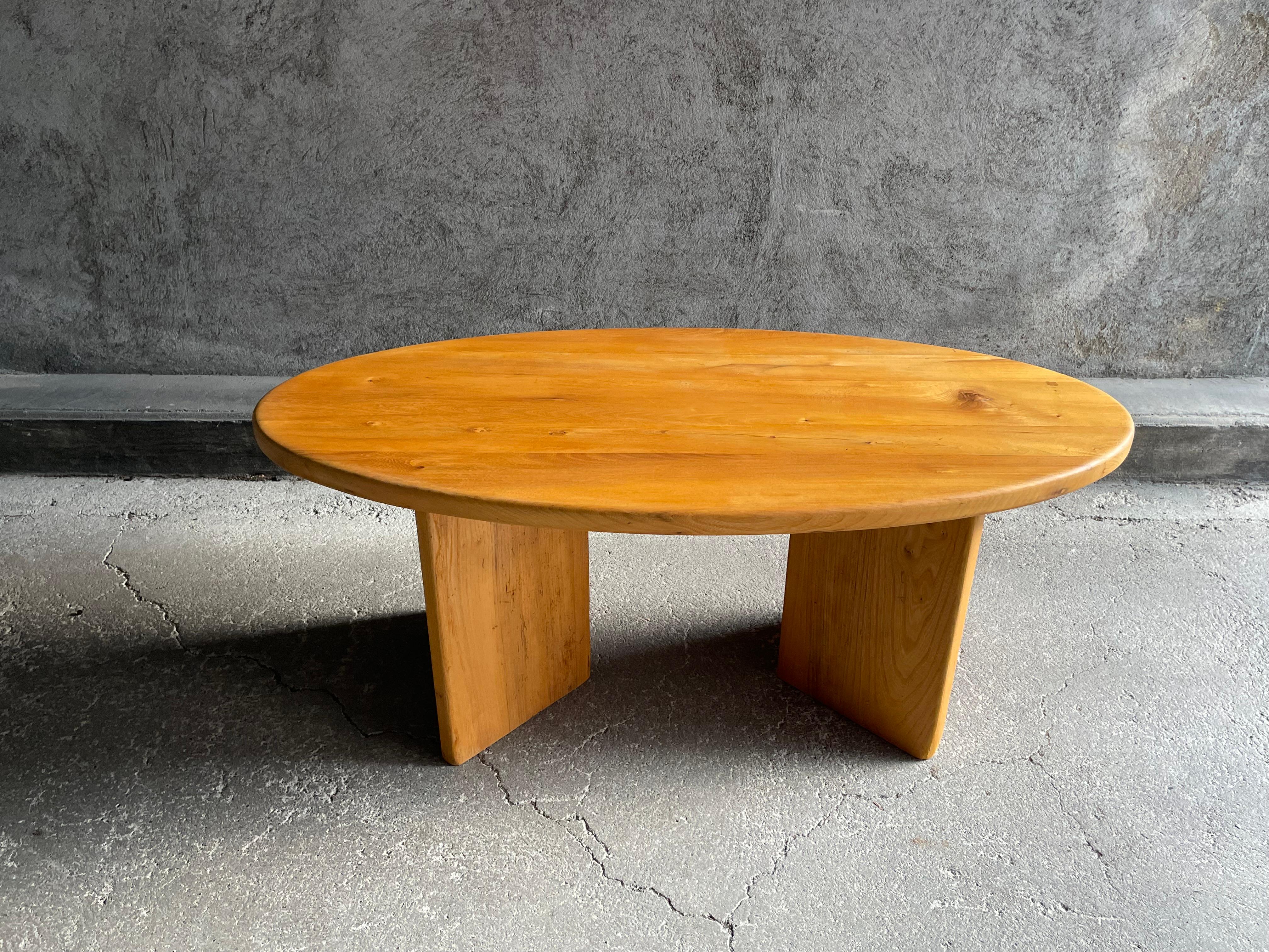 Table basse ovale en orme massif datant des années 1960. Le plateau est posé sur deux pieds en forme de V. Ce mobilier provient probablement d'une maison de montagne. Ces meubles rappellent le travail de célèbres designers et ébénistes français.