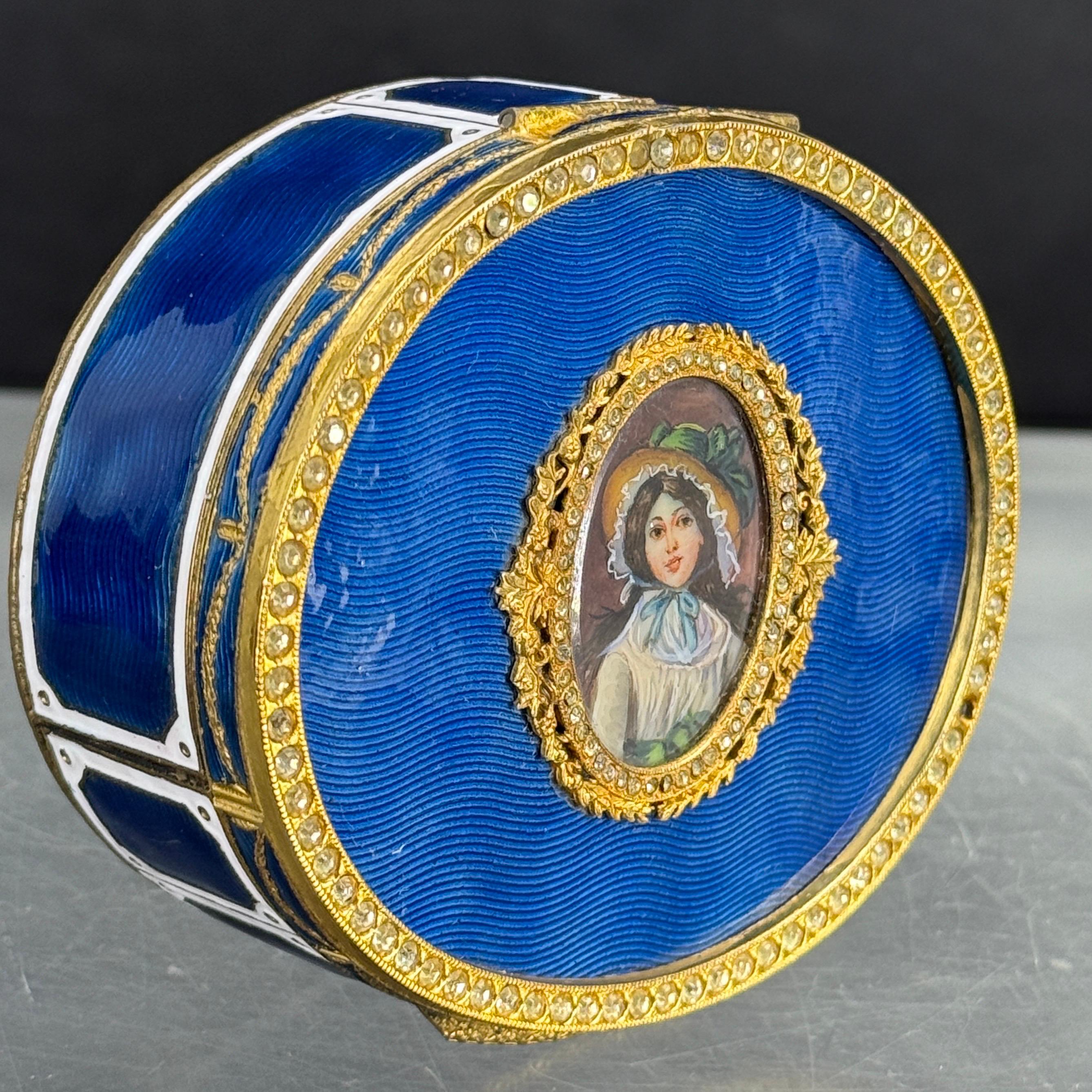 Antique oval blue reuge guilloche enamel jewelry box with gilt bronze decorated framework and hardware. The lid features a hand painted portrait of a lady. This charming box features a blue velvet interior for rings and other jewelry pieces.