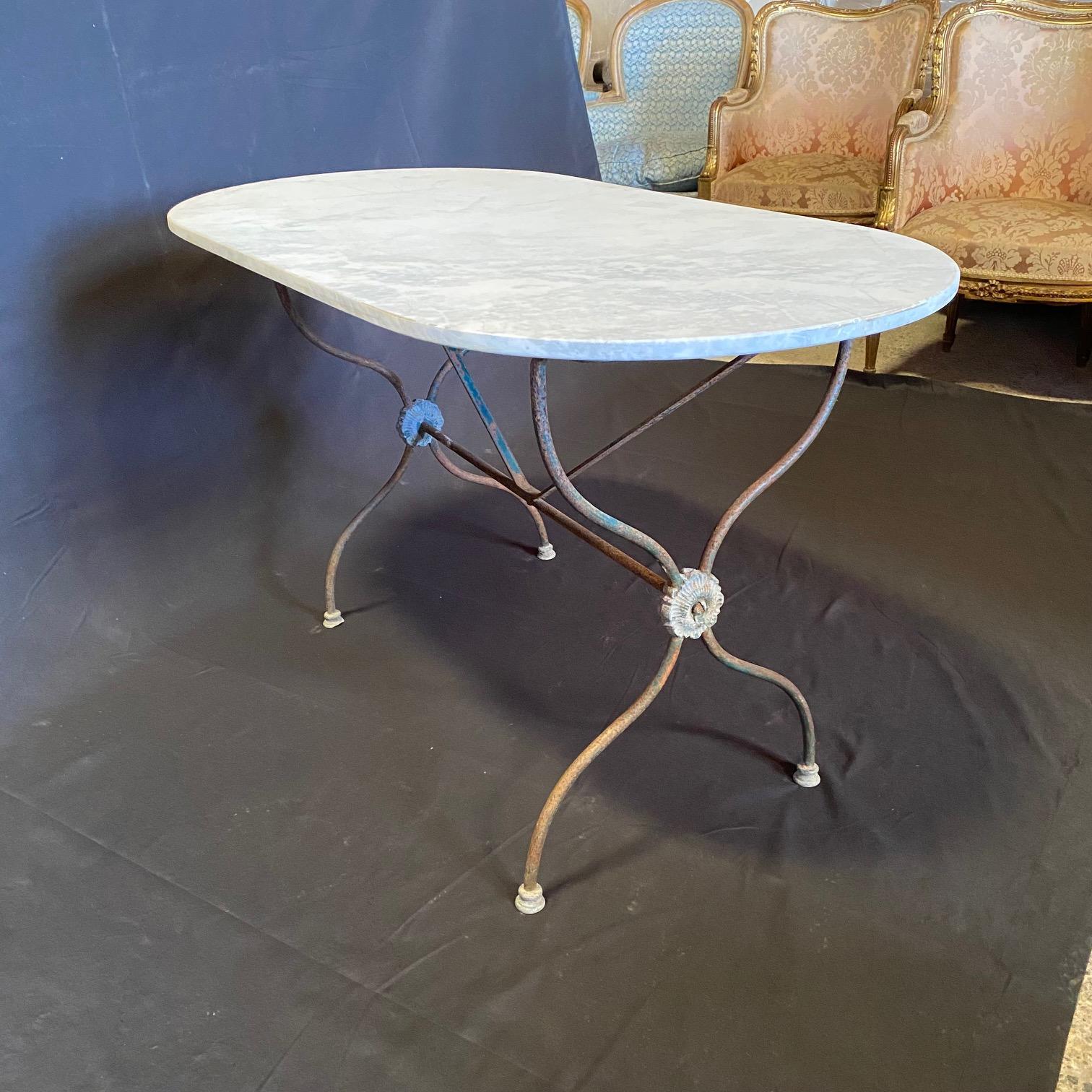 Exquisite French marble top oval cafe table or writing desk with a classic Provincial iron base with center floret design. Marble is a stunning white Carrara marble with pale gray veining. Very nice edge on all four sides - and could be in the