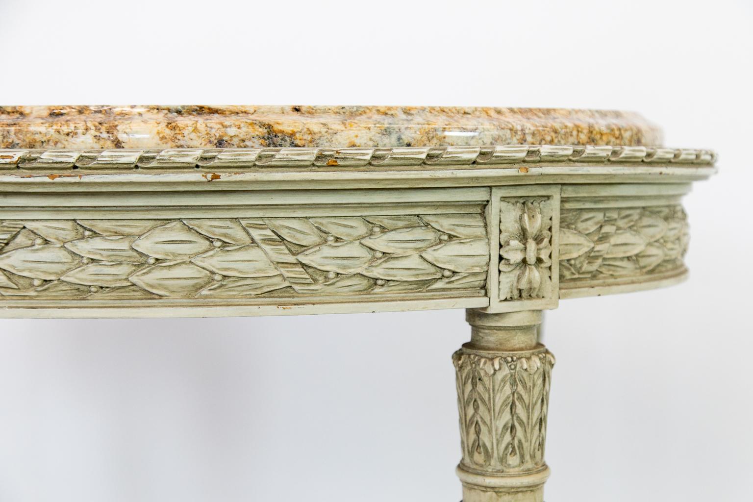 French oval marble-top center table, the frieze with stylized foliate in relief, mirrored on the sides and the ends, the turned and reeded legs taper and terminate with foliate decorated feet. The legs are connected with a concave shaped stretcher