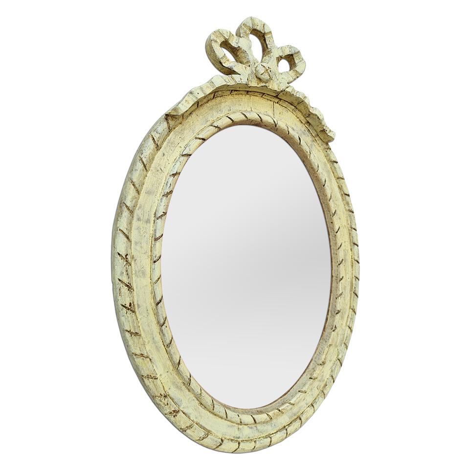 French oval mirror from the 50's in carved wood painted in a patinated light yellow Provencal color, 