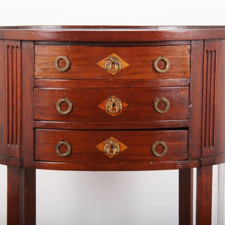 A French oval mahogany-and-inlay side table with three small drawers and a lower shelf,

circa 1900.



  