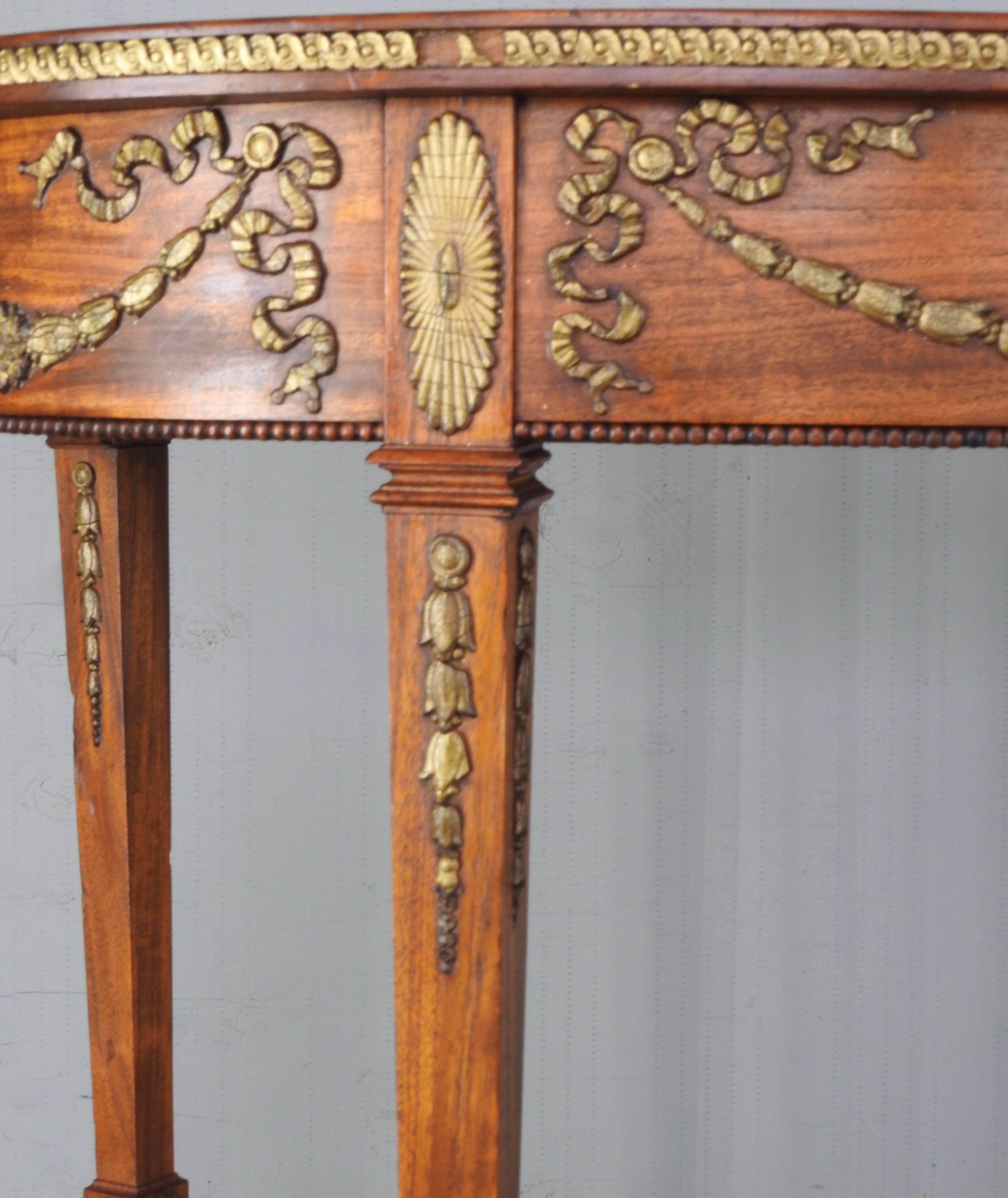 Offering a beautifully crafted French oval table that is accented with detailed hand-carved ormolu on the sides and legs. Sitting atop a gorgeous tapered leg it gracefully rises from the floor. About one third of the way up the legs there is a