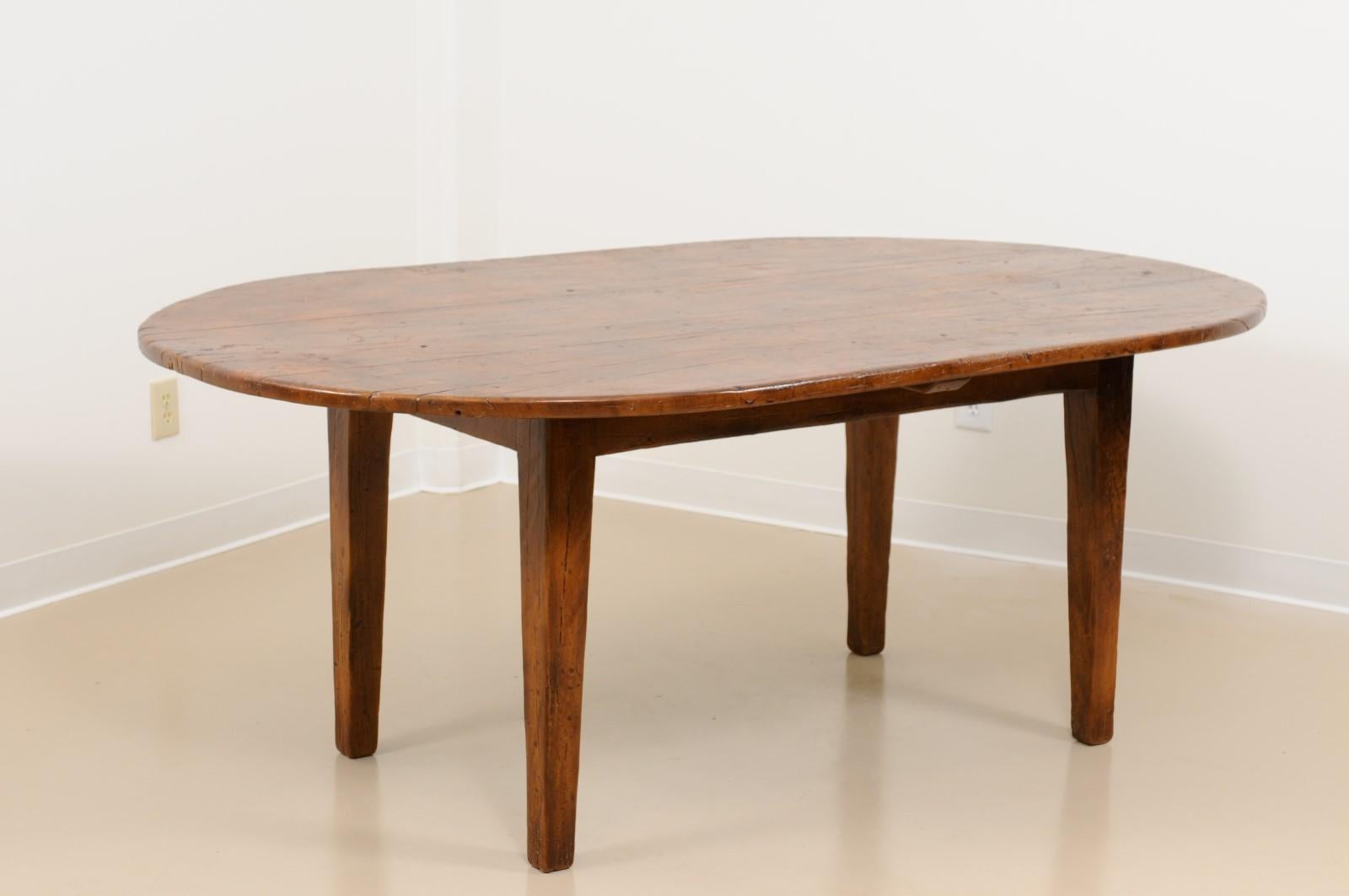 A French oval walnut dining with tapered legs. The table hand made out of solid walnut in the south of France.