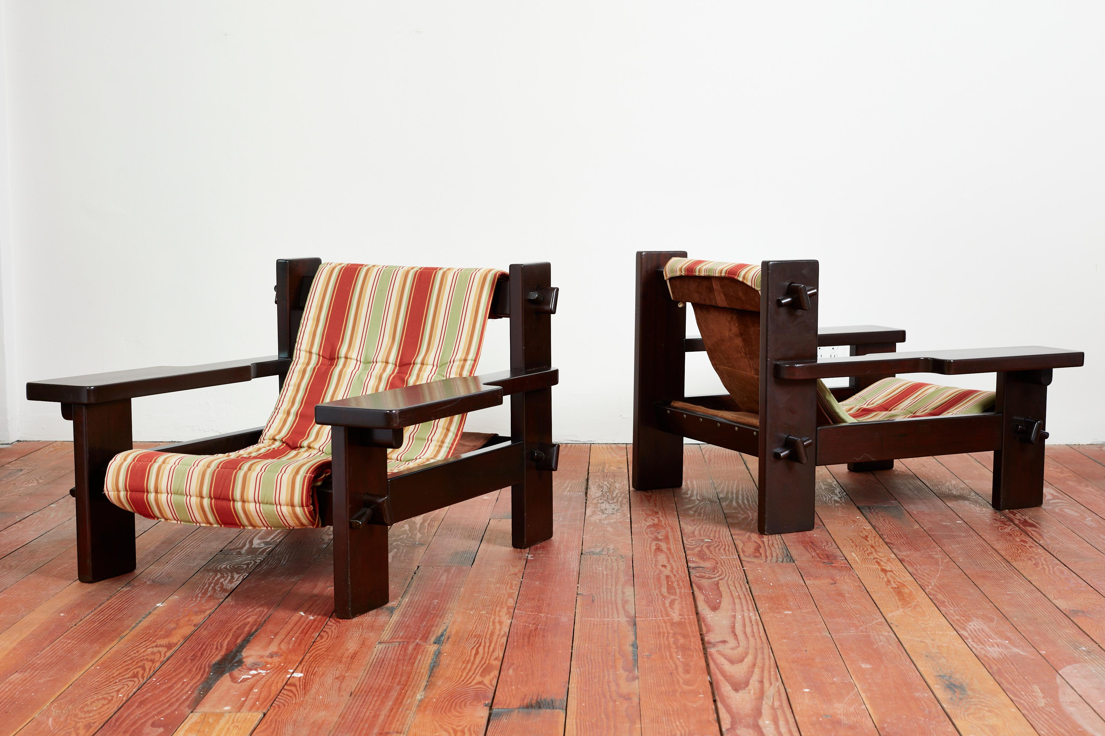 Fantastic large scale pair of Paddle armchairs - Brazil, circa 1950s
Dark wood frame with Wide paddle shaped arms and unique large nut & bolt joinery. 
Sling seat with newly upholstered striped shell onto of leather sling. 
Great pair!