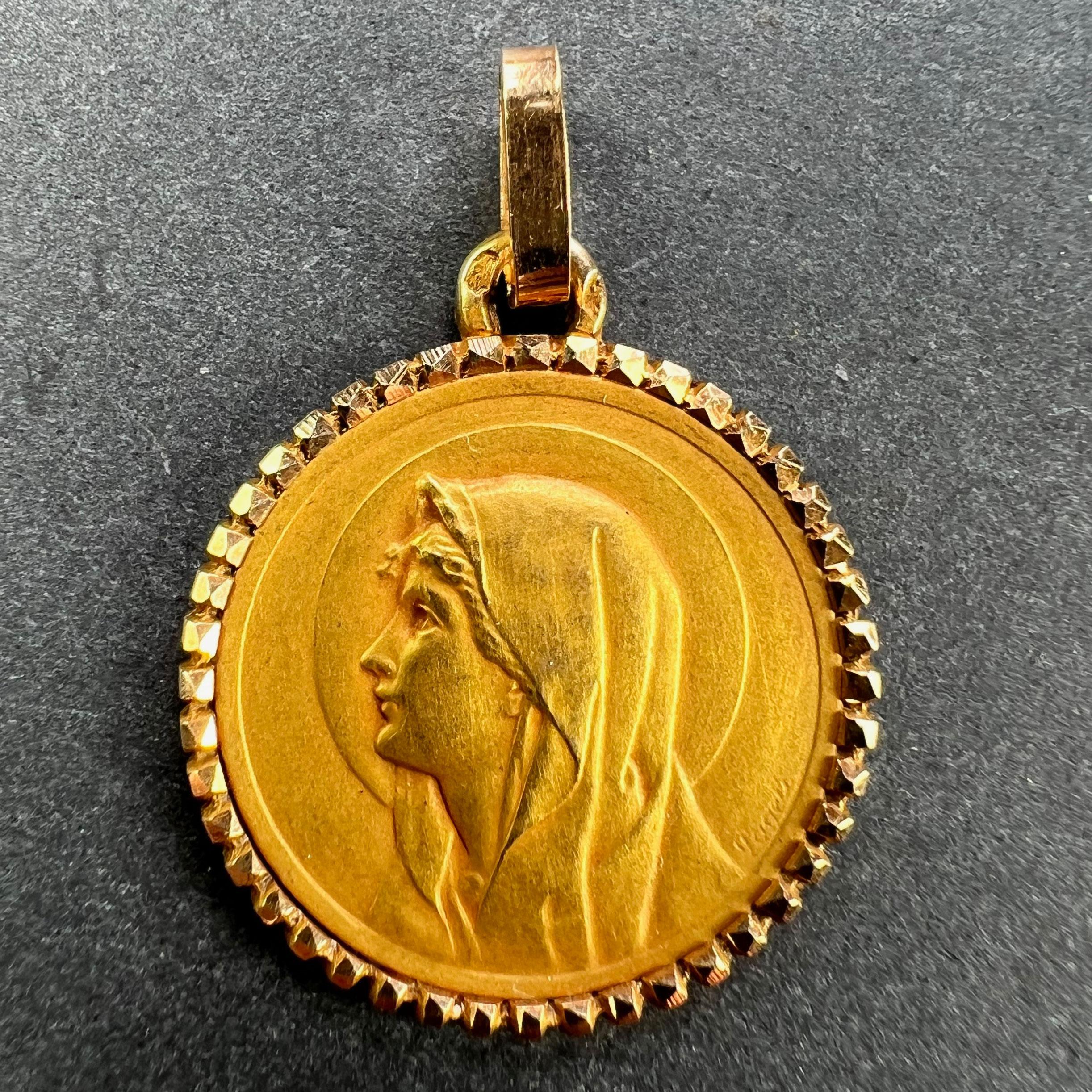 Colgante francés de oro amarillo de 18 quilates (18K), diseñado como una medalla redonda que representa a la Virgen María de perfil con un halo y un borde dentado con cabeza de clavo. Estampado con la cabeza de águila de fabricación francesa y oro