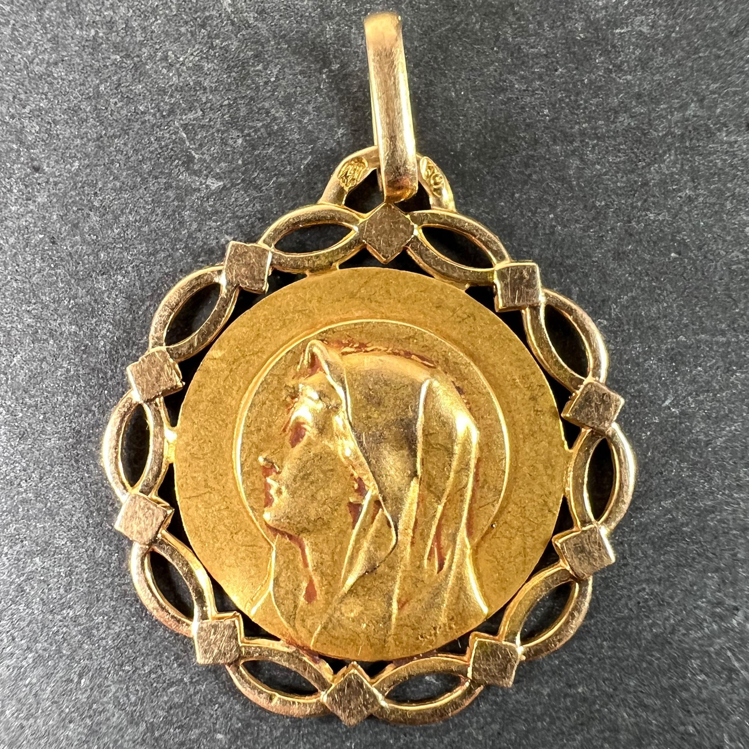 Un ciondolo in oro giallo 18 carati (18K) disegnato come una medaglia rotonda con una cornice geometrica che raffigura la Vergine Maria. Firmato Pageri, timbrato con la testa d'aquila per la manifattura francese e in oro a 18 carati, con marchio del