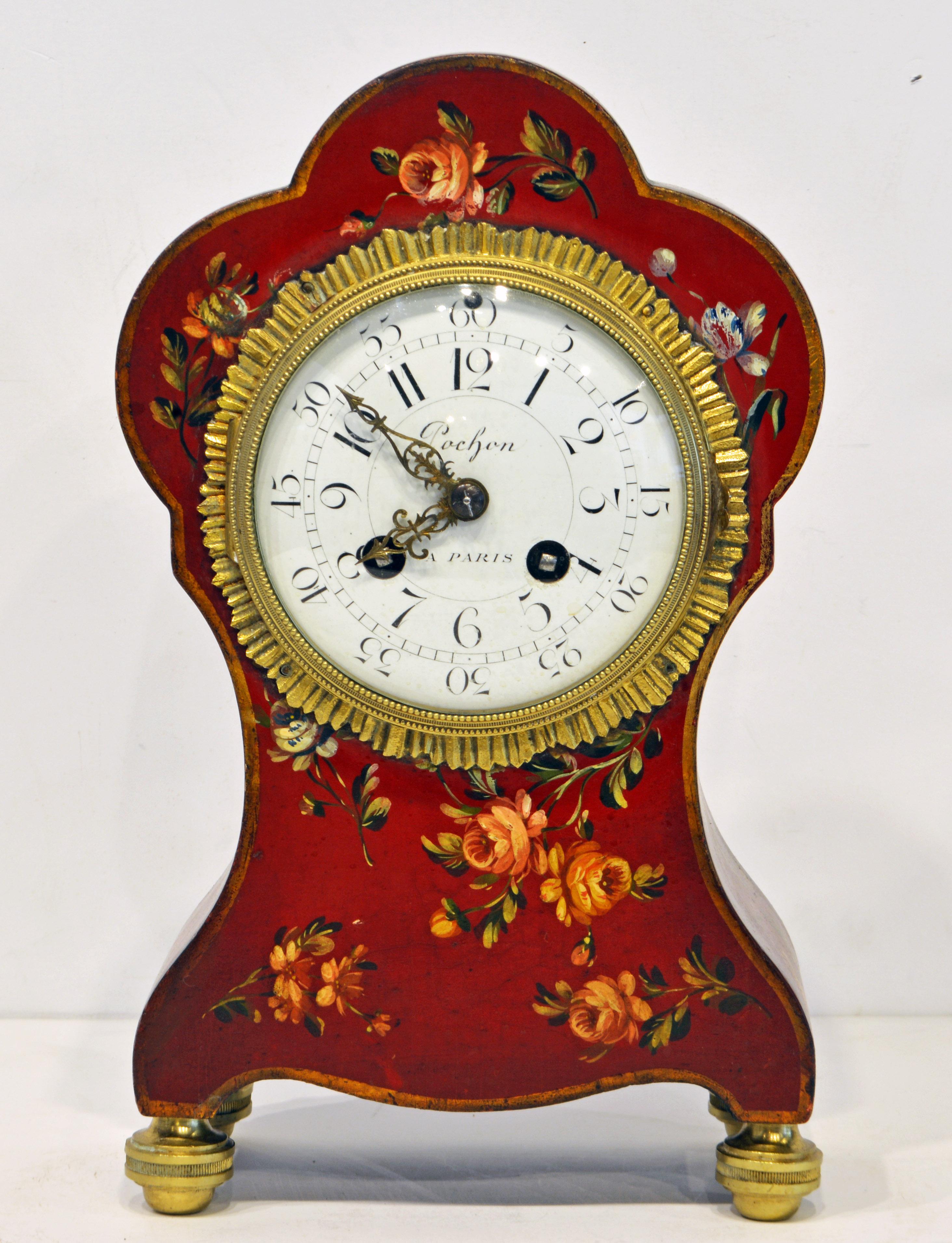 Standing on four sphere shape gilt bronze feet his adorable French Louis Philippe mantel clock features a beautiful shape with soft curves painted in a Venetian red and decorated with flowers and leaf work of great detail. The enamel dial is