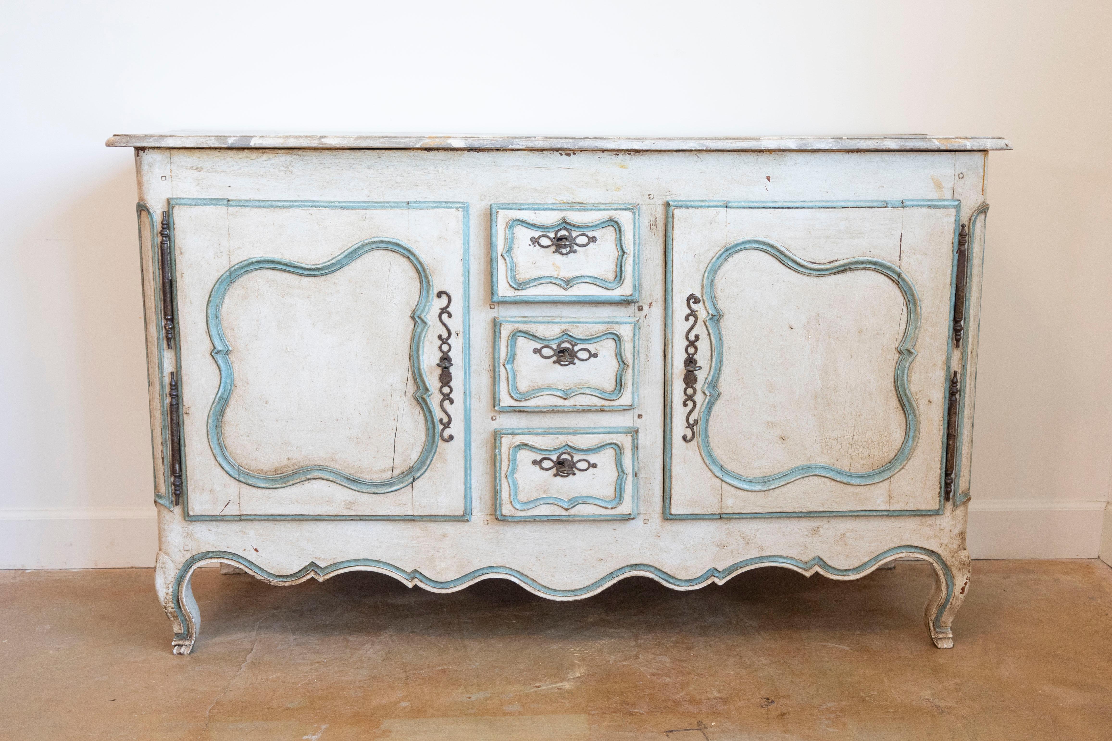 A French Louis XV period painted wood buffet with marbleized top, two doors and three drawers from the mid-18th century. This French buffet features a rectangular faux-marble top with rounded edges overhanging two carved doors flanking three small