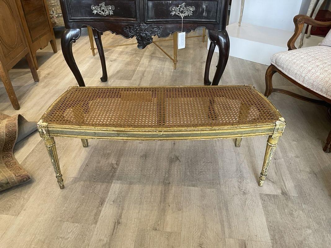 French painted and caned window bench, likely possibly late 19th C., seat with a newly-upholstered cream linen cushion. Caning in good condition. Measures: 15 3/4