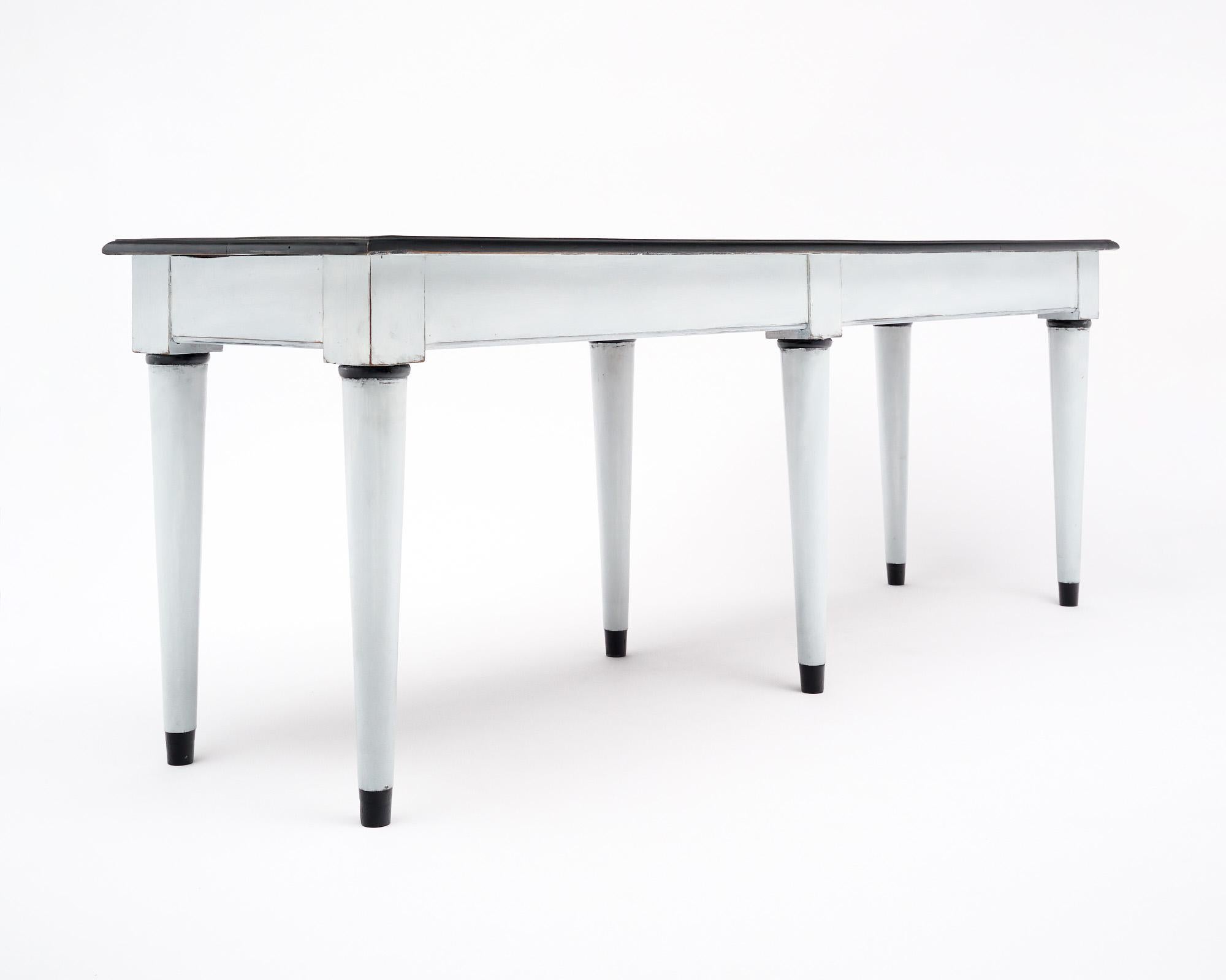 Console table from France made of solid beechwood wood construction and featuring a two-toned milk paint finish. The top and trim are an antique black; while the legs and apron are an antique white tone. This piece is in very nice antique condition