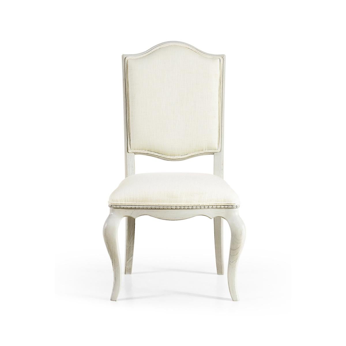 French painted dining chair, Louis XV style painted dining chair, this dining side chair is raised on gently sloped sabre legs with a curved floating back and a bellflower detail. A painted light gray finish and Belgian performance linen provide