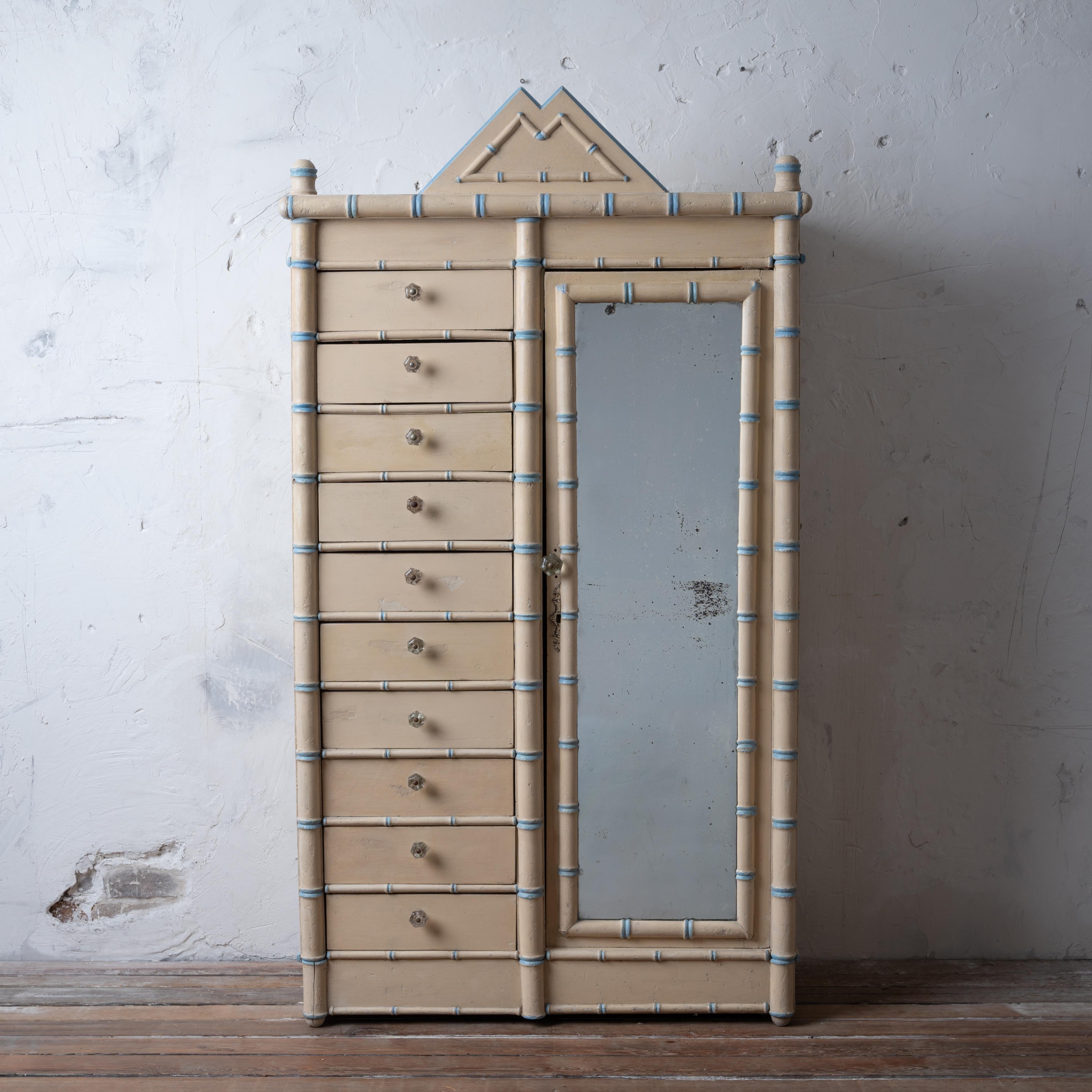 A French painted faux bamboo armoire, circa 1890s. 

Ten drawers with a mirror-front wardrobe.

34 ½ inches wide by 15 ½ inches deep by 63 ½ inches tall

