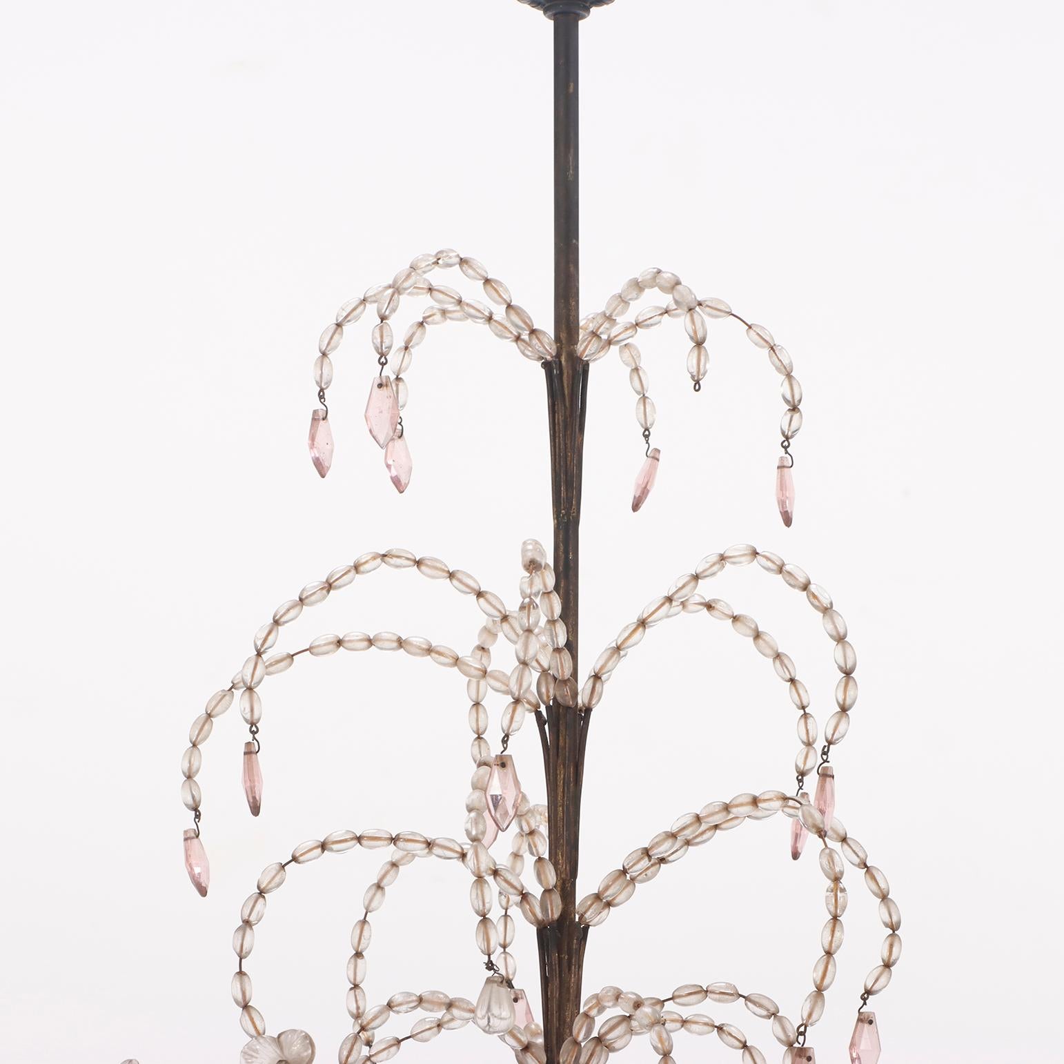 French painted iron and beaded chandelier in the manner of Bagues C 1940. We are unable to test the working condition and we always recommend having lighting elements professionally re-wired for safety purposes.