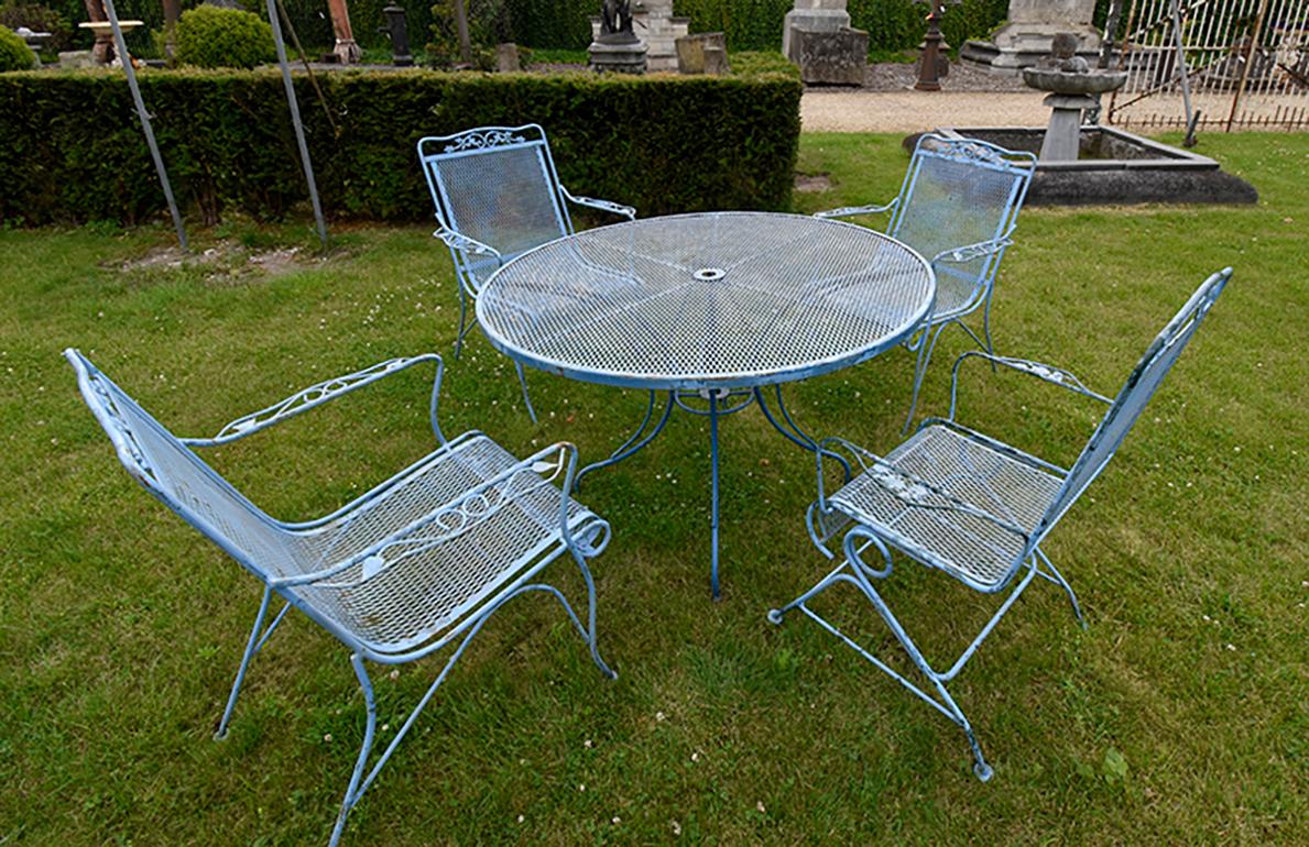 Charming outdoor dining set comprising a table and four chairs, made of wrought iron, 
with cloverleaf pattern on the chair seats. Comes out of the garden of a french mansion.
      