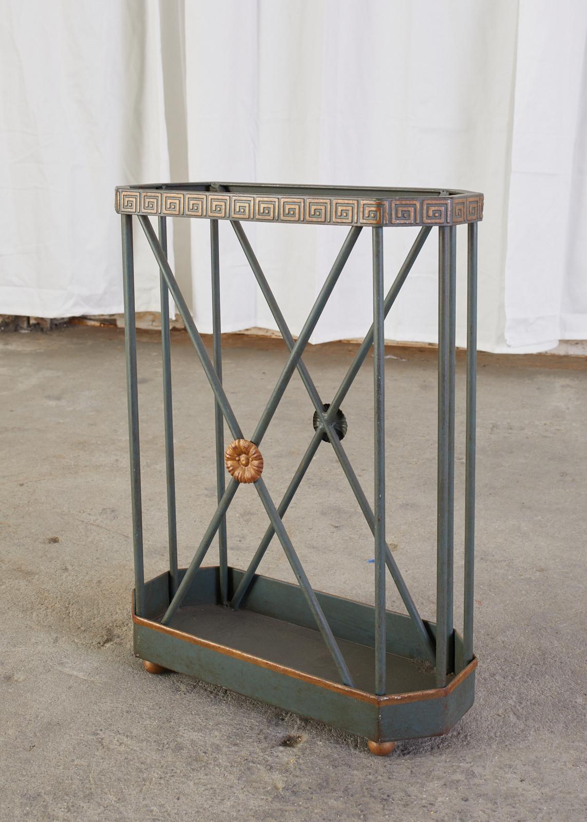 Distinctive French painted umbrella stand or cane walking stick stand made in the neoclassical taste. The iron stand features on X-motif design centered by a rosette on each side. The top has a Greek key motif around the rim. The iron has a dark