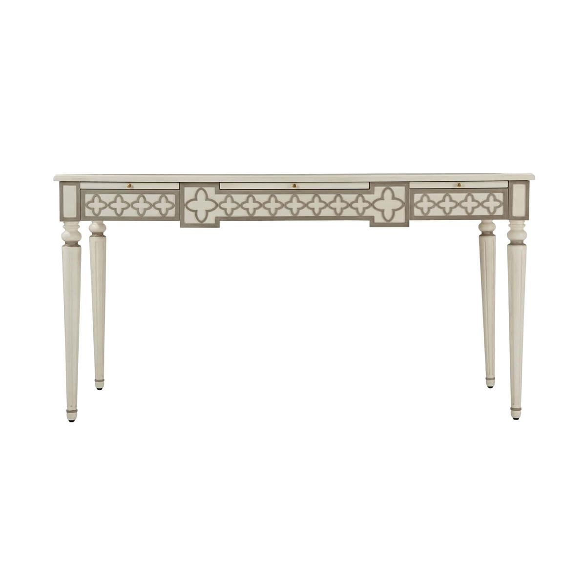 French painted leather top desk, a twist on a classic 18th-century French design. Finished in Salted white and highlighted with gray details, a gilt tooled leather top writing surface and three slide our leather top surfaces, with three frieze